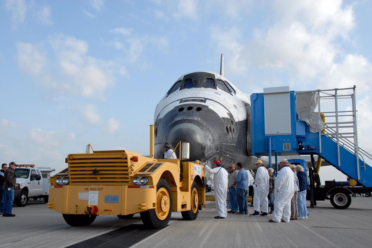 KENNEDY SPACE CENTER, FLA. -- On the Shuttle Landing Facility at NASA's Kennedy Space Center, a tractor tow vehicle is backed up to space shuttle Discovery. Towing normally begins approximately within four hours after landing and is completed within six hours unless removal of time-sensitive experiments require an additional period on the runway. Umbilicals are attached to purge the vehicle of any possible residual explosive or toxic fumes. The tractor tow vehicle will pull Discovery along a two-mile tow-way to the Orbiter Processing Facility, or OPF, where processing Discovery for another flight begins. The tow vehicle is very much like the typical towing units used for large aircraft, but it is equipped with a special towing bar designed specifically for the orbiter. In the OPF, turnaround processing procedures on Discovery will include various post-flight deservicing and maintenance functions, which are carried out in parallel with payload removal and the installation of equipment needed for the next mission. Before post-flight deservicing can continue beyond initial safing operations, certain vehicle systems must be mechanically secured and access platforms installed. Discovery completed mission STS-120 with an on-time landing at 1:01 p.m. EST. Photo credit: NASA/Kim Shiflett