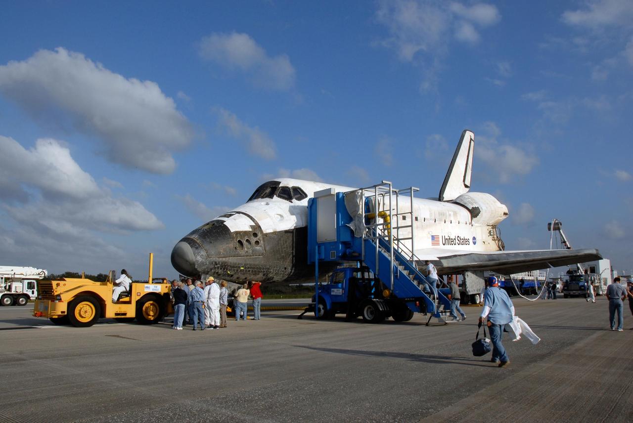 KENNEDY SPACE CENTER, FLA. -- On the Shuttle Landing Facility at NASA's Kennedy Space Center, a tractor tow vehicle is backed up to space shuttle Discovery. Towing normally begins approximately within four hours after landing and is completed within six hours unless removal of time-sensitive experiments require an additional period on the runway. Umbilicals are attached to purge the vehicle of any possible residual explosive or toxic fumes. The tractor tow vehicle will pull Discovery along a two-mile tow-way to the Orbiter Processing Facility, or OPF, where processing Discovery for another flight begins. The tow vehicle is very much like the typical towing units used for large aircraft, but it is equipped with a special towing bar designed specifically for the orbiter. In the OPF, turnaround processing procedures on Discovery will include various post-flight deservicing and maintenance functions, which are carried out in parallel with payload removal and the installation of equipment needed for the next mission. Before post-flight deservicing can continue beyond initial safing operations, certain vehicle systems must be mechanically secured and access platforms installed. Discovery completed mission STS-120 with an on-time landing at 1:01 p.m. EST. Photo credit: NASA/Kim Shiflett
