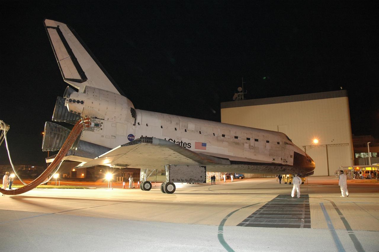 KENNEDY SPACE CENTER, FLA. --  The space shuttle Discovery nears the Orbital Processing Facility, or OPF, where processing Discovery for another flight begins.  Towing normally begins within four hours after landing and is completed within six hours unless removal of time-sensitive experiments is required on the runway.  Umbilicals are attached to purge the vehicle of any possible residual explosive or toxic fumes.   In the OPF, turnaround processing procedures on Discovery will include various post-flight deservicing and maintenance functions, which are carried out in parallel with payload removal and the installation of equipment needed for the next mission.  Before post-flight deservicing can continue beyond initial safing operations, certain vehicle systems must be mechanically secured and access platforms installed.  Discovery completed mission STS-120 with an on-time landing at 1:01 p.m. EST. Photo credit: NASA/Jim Grossmann