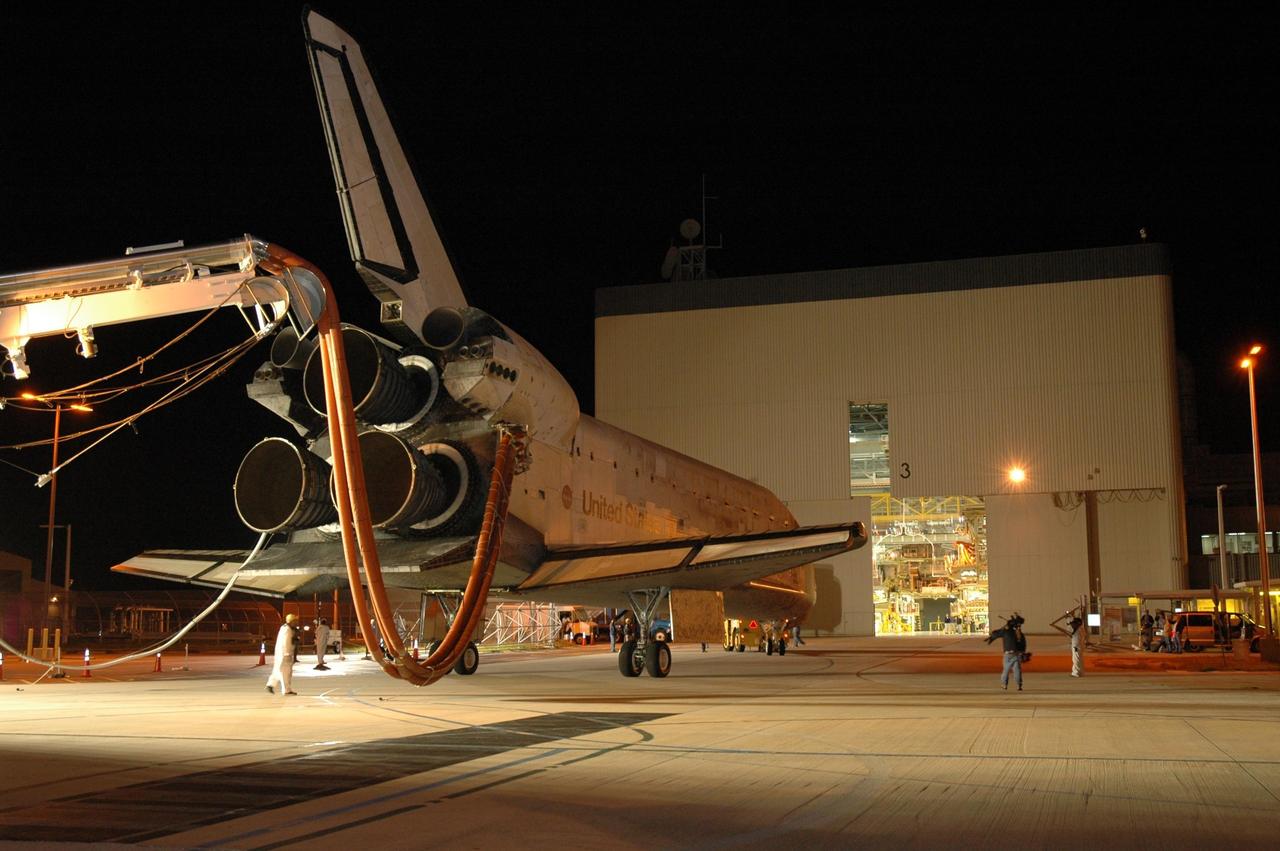 KENNEDY SPACE CENTER, FLA. --  The space shuttle Discovery nears the Orbital Processing Facility, or OPF, where processing Discovery for another flight begins.  Towing normally begins within four hours after landing and is completed within six hours unless removal of time-sensitive experiments is required on the runway.  Umbilicals are attached to purge the vehicle of any possible residual explosive or toxic fumes.   In the OPF, turnaround processing procedures on Discovery will include various post-flight deservicing and maintenance functions, which are carried out in parallel with payload removal and the installation of equipment needed for the next mission.  Before post-flight deservicing can continue beyond initial safing operations, certain vehicle systems must be mechanically secured and access platforms installed.  Discovery completed mission STS-120 with an on-time landing at 1:01 p.m. EST. Photo credit: NASA/Jim Grossmann