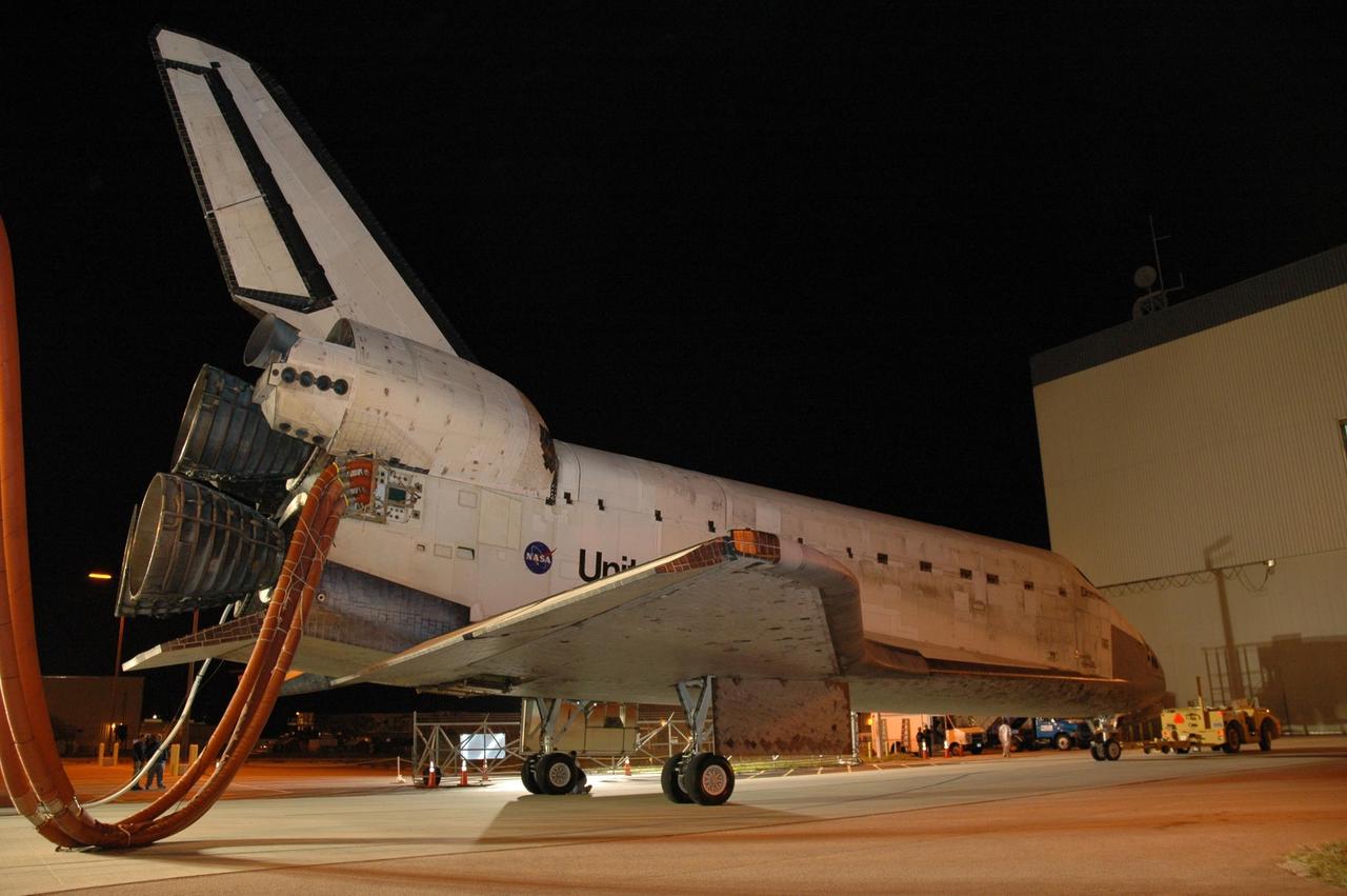 KENNEDY SPACE CENTER, FLA. --  The space shuttle Discovery nears the Orbital Processing Facility, or OPF, where processing Discovery for another flight begins.  Towing normally begins within four hours after landing and is completed within six hours unless removal of time-sensitive experiments is required on the runway.  Umbilicals are attached to purge the vehicle of any possible residual explosive or toxic fumes.  In the OPF, turnaround processing procedures on Discovery will include various post-flight deservicing and maintenance functions, which are carried out in parallel with payload removal and the installation of equipment needed for the next mission.  Before post-flight deservicing can continue beyond initial safing operations, certain vehicle systems must be mechanically secured and access platforms installed.  Discovery completed mission STS-120 with an on-time landing at 1:01 p.m. EST. Photo credit: NASA/Jim Grossmann