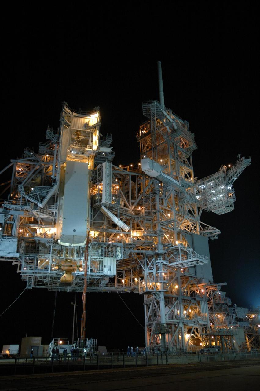 KENNEDY SPACE CENTER, FLA. -- With umbilical lines still attached, the payload canister containing the Columbus Laboratory module and integrated cargo carrier-lite is lifted up toward the payload changeout room on Launch Pad 39A at NASA's Kennedy Space Center. Once in place, the canister will be opened and the module transferred inside the payload changeout room. The payload will be installed in space shuttle Atlantis' payload bay. The canister contains the Columbus Lab module and integrated cargo carrier-lite payloads for space shuttle Atlantis on mission STS-122. Atlantis is targeted to launch on Dec. 6. Photo credit: NASA/Dimitri Gerondidakis