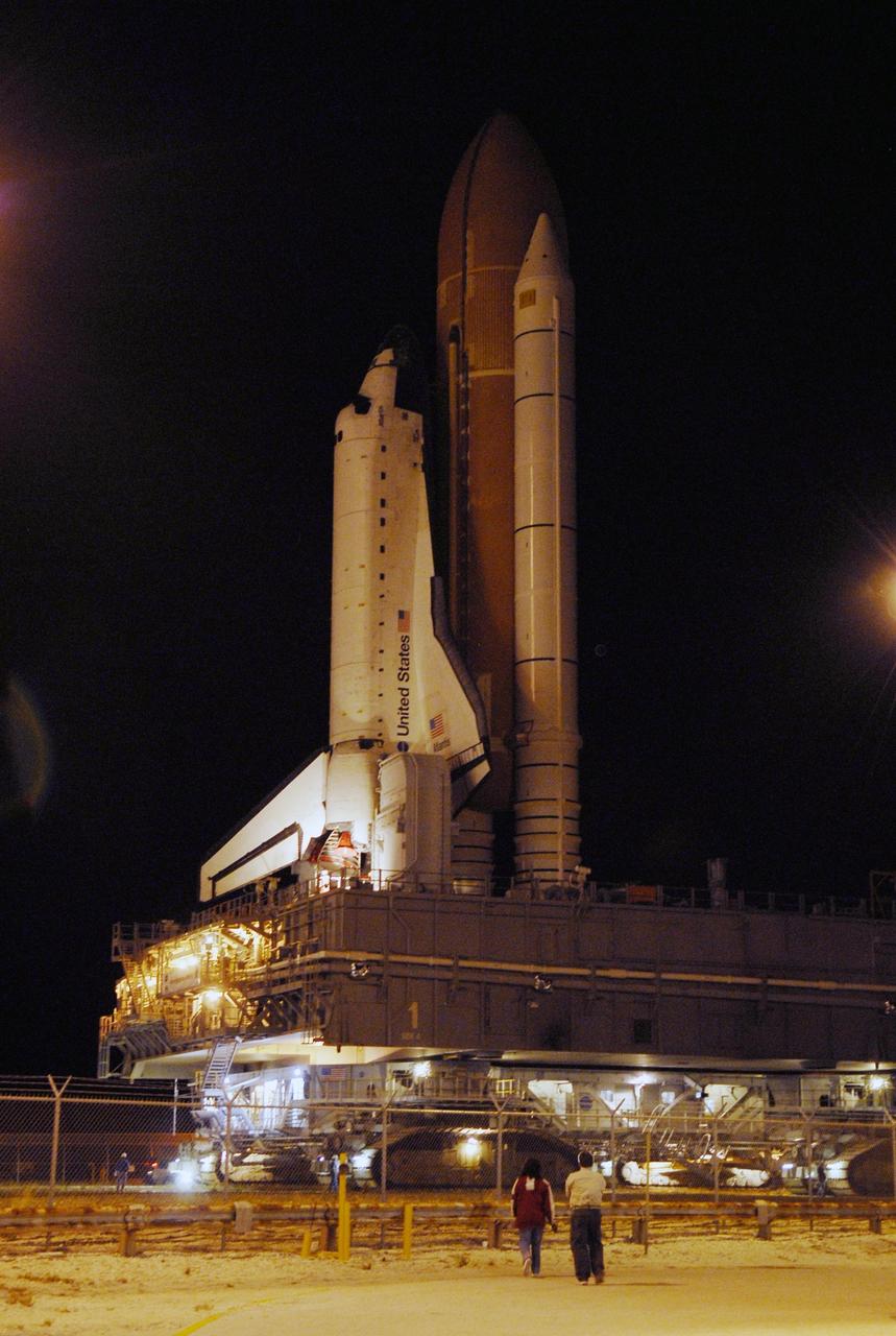 KENNEDY SPACE CENTER, FLA. -- Workers monitor the progress of Space Shuttle Atlantis as it moves through the doors of the Vehicle Assembly Building along the crawlerway toward Launch Pad 39A. First motion out of the VAB was at 4:43 a.m. EST. Rollout is a milestone for Atlantis' launch to the International Space Station on mission STS-122, targeted for Dec. 6. On this mission, Atlantis will deliver the Columbus module to the International Space Station. The European Space Agency's largest contribution to the station, Columbus is a multifunctional, pressurized laboratory that will be permanently attached to U.S. Node 2, called Harmony. The module is approximately 23 feet long and 15 feet wide, allowing it to hold 10 large racks of experiments. The laboratory will expand the research facilities aboard the station, providing crew members and scientists from around the world the ability to conduct a variety of experiments in the physical, materials and life sciences. Photo credit: NASA/Kim Shiflett