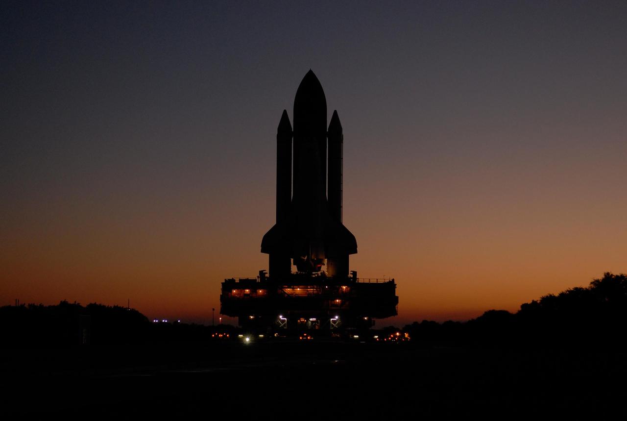 KENNEDY SPACE CENTER, FLA. -- A crawler transporter moves Space Shuttle Atlantis, secured atop a mobile launch platform, along the crawlerway from the Vehicle Assembly Building to Launch Pad 39A as the sun rises. First motion out of the VAB was at 4:43 a.m. EST. The crawler transporter, mobile launch platform and unfueled space shuttle weigh a total of approximately 17.5 million pounds. Rollout is a milestone for Atlantis' launch to the International Space Station on mission STS-122, targeted for Dec. 6. On this mission, Atlantis will deliver the Columbus module to the International Space Station. The European Space Agency's largest contribution to the station, Columbus is a multifunctional, pressurized laboratory that will be permanently attached to U.S. Node 2, called Harmony. The module is approximately 23 feet long and 15 feet wide, allowing it to hold 10 large racks of experiments. The laboratory will expand the research facilities aboard the station, providing crew members and scientists from around the world the ability to conduct a variety of experiments in the physical, materials and life sciences. Photo credit: NASA/Kim Shiflett