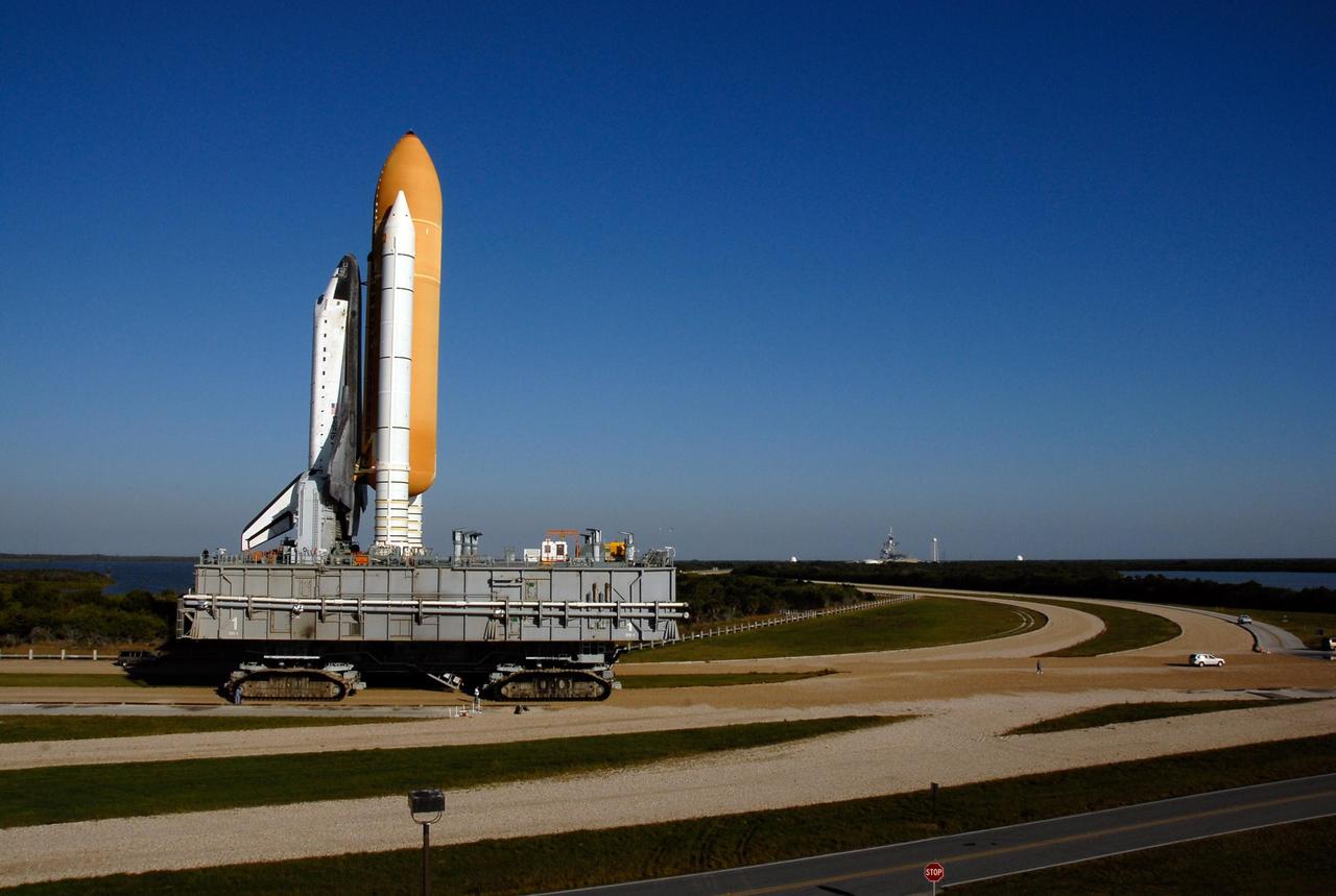 KENNEDY SPACE CENTER, FLA. -- Space Shuttle Atlantis, secured atop a mobile launch platform, rounds a curve on the crawlerway in Launch Complex 39 on its way to Pad A. The crawler transporter has a top speed of one mile per hour while it is moving the space shuttle. First motion out of the Vehicle Assembly Building was at 4:43 a.m. EST. Rollout is a milestone for Atlantis' launch to the International Space Station on mission STS-122, targeted for Dec. 6. On this mission, Atlantis will deliver the Columbus module to the International Space Station. The European Space Agency's largest contribution to the station, Columbus is a multifunctional, pressurized laboratory that will be permanently attached to U.S. Node 2, called Harmony. The module is approximately 23 feet long and 15 feet wide, allowing it to hold 10 large racks of experiments. The laboratory will expand the research facilities aboard the station, providing crew members and scientists from around the world the ability to conduct a variety of experiments in the physical, materials and life sciences. Photo credit: NASA/Kim Shiflett