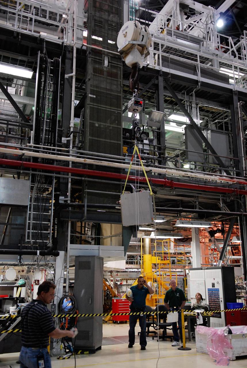KENNEDY SPACE CENTER, FLA. -- In the Orbiter Processing Facility, one of two Materials International Space Station Experiments, or MISSE, is moved across facility toward space shuttle Endeavour. The MISSE is part of the payload onboard Endeavour for mission STS-123 and will be installed in the payload bay. The MISSE project is a NASA/Langley Research Center-managed cooperative endeavor to fly materials and other types of space exposure experiments on the International Space Station. The objective is to develop early, low-cost, non-intrusive opportunities to conduct critical space exposure tests of space materials and components planned for use on future spacecraft. Photo credit: NASA/Kim Shiflett