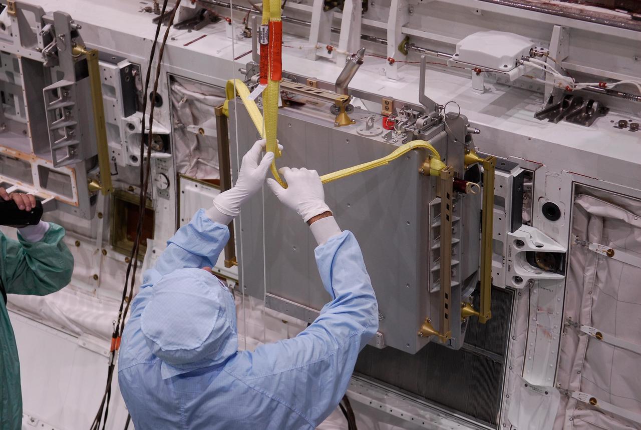 KENNEDY SPACE CENTER, FLA. -- In the Orbiter Processing Facility, one of two Materials International Space Station Experiments, or MISSE, is lowered into space shuttle Endeavour's payload bay for installation. The MISSE is part of the payload onboard Endeavour for mission STS-123. The MISSE project is a NASA/Langley Research Center-managed cooperative endeavor to fly materials and other types of space exposure experiments on the International Space Station. The objective is to develop early, low-cost, non-intrusive opportunities to conduct critical space exposure tests of space materials and components planned for use on future spacecraft. Photo credit: NASA/Kim Shiflett