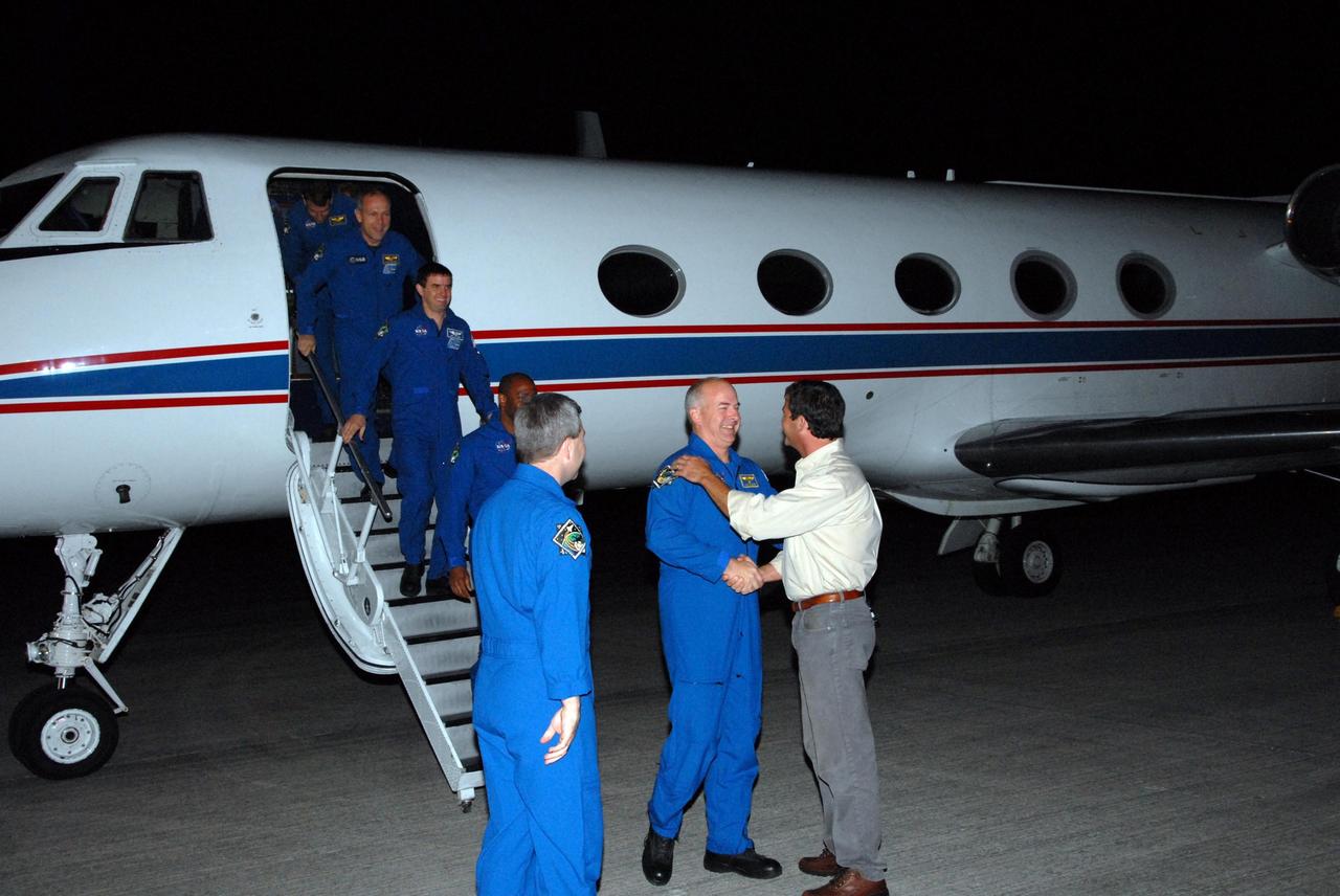 KENNEDY SPACE CENTER, FLA. --  The astronauts assigned to the space shuttle Atlantis STS-122 crew arrive at Kennedy Space Center's Shuttle Landing Facility aboard a Gulfstream shuttle training aircraft to participate in three days of terminal countdown demonstration test, or TCDT, activities. STS-122 Launch Director Doug Lyons greets Pilot Alan Poindexter as Commander Steve Frick looks on.  Disembarking are Mission Specialists Leland Melvin, Rex Walheim, Hans Schlegel of the European Space Agency and Stanley Love. The TCDT provides astronauts and ground crews with equipment familiarization, emergency egress training and a simulated launch countdown. On mission STS-122, Atlantis will deliver the Columbus module to the International Space Station. The European Space Agency's largest single contribution to the station, Columbus is a multifunctional, pressurized laboratory that will be permanently attached to U.S. Node 2, called Harmony. The laboratory will expand the research facilities aboard the station, providing crew members and scientists from around the world the ability to conduct a variety of experiments in the physical, materials and life sciences. Photo credit: NASA/George Shelton