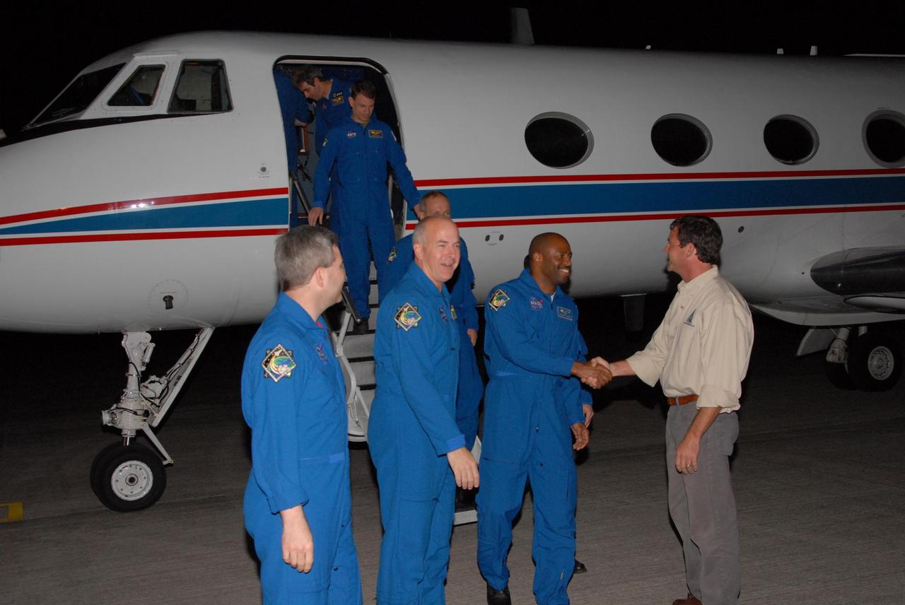 KENNEDY SPACE CENTER, FLA. --  The astronauts assigned to the space shuttle Atlantis STS-122 crew arrive at Kennedy Space Center's Shuttle Landing Facility aboard a Gulfstream shuttle training aircraft to participate in three days of terminal countdown demonstration test, or TCDT, activities. STS-122 Launch Director Doug Lyons greets Mission Specialist Leland Melvin as Commander Steve Frick and Pilot Alan Poindexter look on.  Disembarking are Mission Specialists Hans Schlegel of the European Space Agency, Stanley Love and Leopold Eyharts, a European Space Agency astronaut who will remain on the International Space Station as a flight engineer for Expedition 16. The TCDT provides astronauts and ground crews with equipment familiarization, emergency egress training and a simulated launch countdown. On mission STS-122, Atlantis will deliver the Columbus module to the International Space Station. The European Space Agency's largest single contribution to the station, Columbus is a multifunctional, pressurized laboratory that will be permanently attached to U.S. Node 2, called Harmony. The laboratory will expand the research facilities aboard the station, providing crew members and scientists from around the world the ability to conduct a variety of experiments in the physical, materials and life sciences. Photo credit: NASA/George Shelton