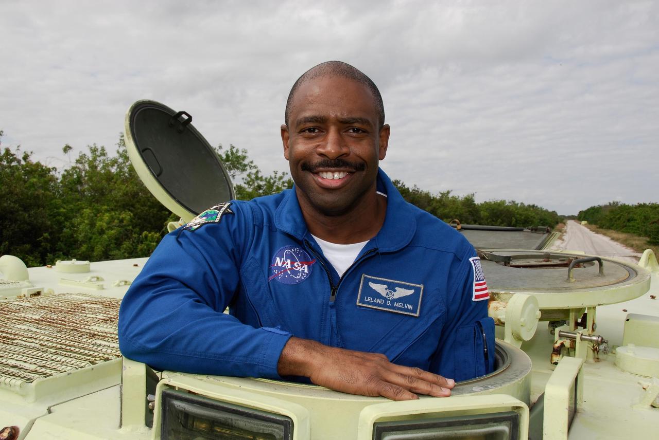 KENNEDY SPACE CENTER, FLA. --  STS-122 Mission Specialist Leland Melvin takes time out from driving practice of the M-113 armored personnel carrier to pose for a photo.  The practice near Launch Pad 39B is part of training on emergency egress procedures. An M-113 will be available to transport the crew to safety in the event of a contingency on the pad before their launch.  The crew is participating in Terminal Countdown Demonstration Test activities, a standard part of launch preparations. The TCDT provides astronauts and ground crews with equipment familiarization, emergency egress training and a simulated launch countdown. On mission STS-122, Atlantis will deliver the European Space Agency's Columbus module to the International Space Station.  Columbus is a multifunctional, pressurized laboratory that will be permanently attached to U.S. Node 2, called Harmony, and will expand the research facilities aboard the station. Launch is targeted for Dec. 6.  Photo credit: NASA/Kim Shiflett