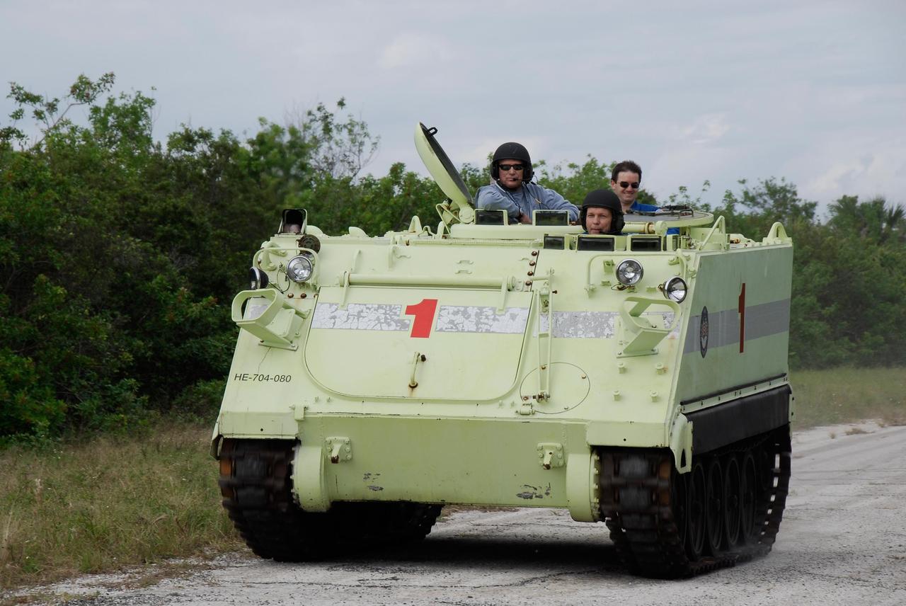 KENNEDY SPACE CENTER, FLA. --  STS-122 Mission Specialist Hans Schlegel, of the European Space Agency, in front, practices driving an M-113 armored personnel carrier as the instructor, to his left, monitors his performance.  STS-122 Mission Specialist Rex Walheim, at right, enjoys the ride in back.  The practice near Launch Pad 39B is part of training on emergency egress procedures. An M-113 will be available to transport the crew to safety in the event of a contingency on the pad before their launch.  The crew is participating in Terminal Countdown Demonstration Test activities, a standard part of launch preparations. The TCDT provides astronauts and ground crews with equipment familiarization, emergency egress training and a simulated launch countdown. On mission STS-122, Atlantis will deliver the European Space Agency's Columbus module to the International Space Station.  Columbus is a multifunctional, pressurized laboratory that will be permanently attached to U.S. Node 2, called Harmony, and will expand the research facilities aboard the station. Launch is targeted for Dec. 6.  Photo credit: NASA/Kim Shiflett