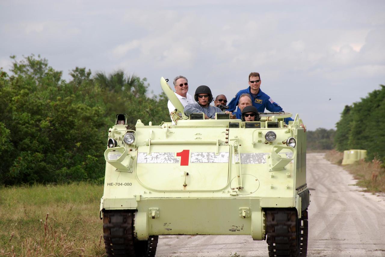 KENNEDY SPACE CENTER, FLA. --  STS-122 Mission Specialist Leopold Eyharts of the European Space Agency, in front, practices driving an M-113 armored personnel carrier as the instructor, in the helmet beside him, monitors his performance.  Eyharts will remain on the International Space Station as a flight engineer for Expedition 16 following the STS-122 mission. In back from left, former astronaut Jerry Ross, chief of the Vehicle Integration Test Office at NASA Johnson Space Center, and STS-122 Mission Specialists Leland Melvin, Stanley Love (standing) and Hans Schlegel of the European Space Agency, are along for the ride. The practice near Launch Pad 39B is part of training on emergency egress procedures. An M-113 will be available to transport the crew to safety in the event of a contingency on the pad before their launch.  The crew is participating in Terminal Countdown Demonstration Test activities, a standard part of launch preparations. The TCDT provides astronauts and ground crews with equipment familiarization, emergency egress training and a simulated launch countdown. On mission STS-122, Atlantis will deliver the European Space Agency's Columbus module to the International Space Station.  Columbus is a multifunctional, pressurized laboratory that will be permanently attached to U.S. Node 2, called Harmony, and will expand the research facilities aboard the station. Launch is targeted for Dec. 6.  Photo credit: NASA/Kim Shiflett