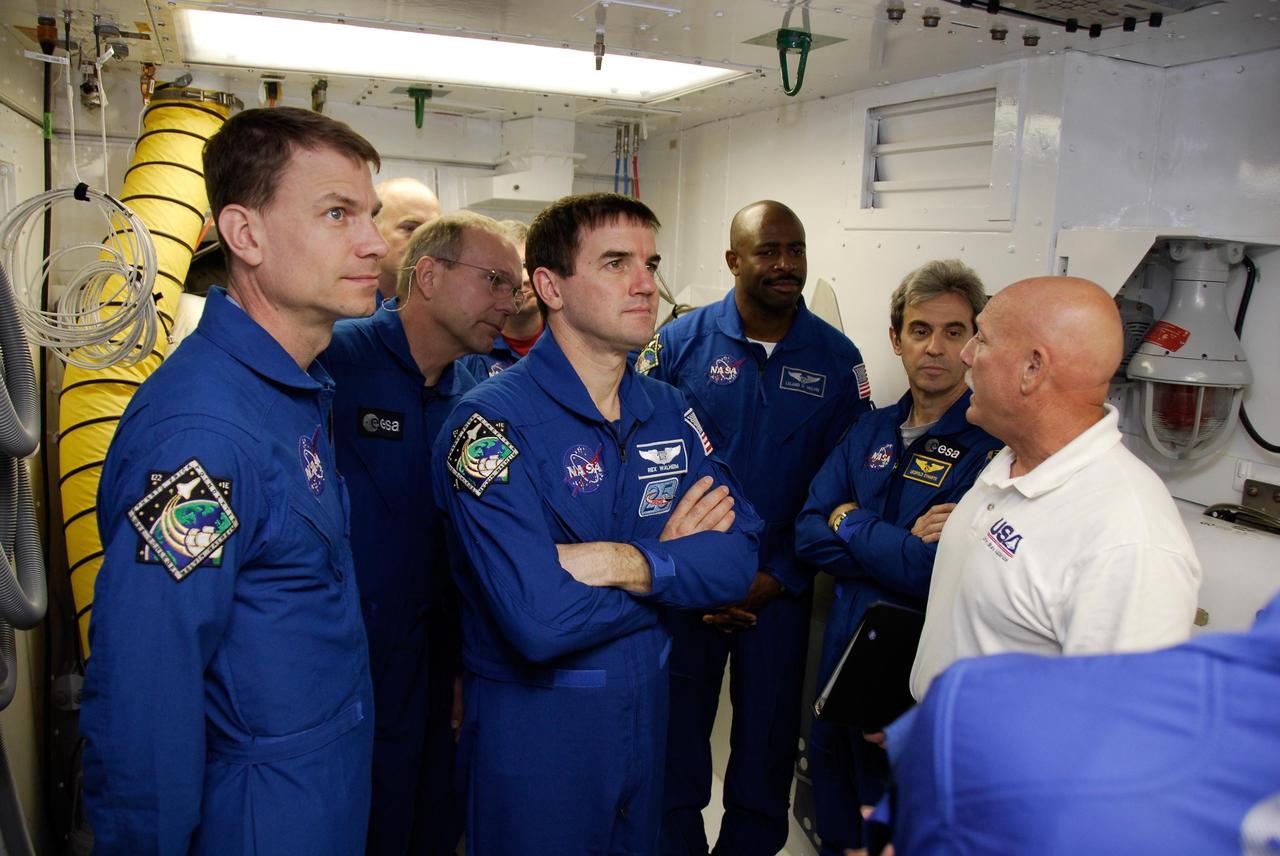 KENNEDY SPACE CENTER, FLA. -- Gathered in the white room on Launch Pad 39A, the space shuttle Atlantis STS-122 crew members listen to an instructor explain space shuttle emergency exit procedures. From left are Mission Specialists Stanley Love, Hans Schlegel, Rex Walheim, Leland Melvin and Leopold Eyharts. Pilot Alan Poindexter and Commander Steve Frick are standing behind them. The STS-122 crew is at NASA's Kennedy Space Center to take part in terminal countdown demonstration test, or TCDT, activities, a standard part of launch preparations. The TCDT provides astronauts and ground crews with equipment familiarization and a simulated launch countdown before launch. On mission STS-122, Atlantis will deliver the European Space Agency's Columbus module to the International Space Station. Columbus is a multifunctional, pressurized laboratory that will be permanently attached to U.S. Node 2, called Harmony, and will expand the research facilities aboard the station. Launch is targeted for Dec. 6. Photo credit: NASA/Kim Shiflett