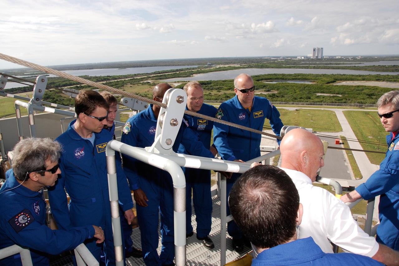 KENNEDY SPACE CENTER, FLA. -- The space shuttle Atlantis STS-122 crew receives instruction on emergency exit from the fixed service structure on Launch Pad 39A. Clockwise, from left, are Mission Specialists Leopold Eyharts and Stanley Love, Eyharts' backup Frank De Winne, Mission Specialists Leland Melvin and Hans Schlegel, Pilot Alan Poindexter, Commander Steve Frick and Mission Specialist Rex Walheim with his back to the camera. Schlegel, Eyharts and De Winne are with the European Space Agency. Eyharts will remain on the International Space Station as a flight engineer for Expedition 16 following the STS-122 mission. The STS-122 crew is at NASA's Kennedy Space Center to take part in terminal countdown demonstration test, or TCDT, activities, a standard part of launch preparations. The TCDT provides astronauts and ground crews with equipment familiarization and a simulated launch countdown before launch. On mission STS-122, Atlantis will deliver the European Space Agency's Columbus module to the International Space Station. Columbus is a multifunctional, pressurized laboratory that will be permanently attached to U.S. Node 2, called Harmony, and will expand the research facilities aboard the station. Launch is targeted for Dec. 6. Photo credit: NASA/Kim Shiflett