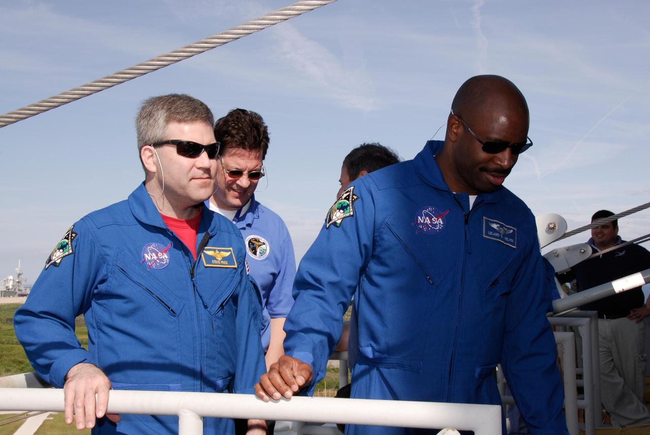 KENNEDY SPACE CENTER, FLA. -- During a training session on emergency exit from the fixed service structure on Launch Pad 39A, space shuttle Atlantis STS-122 Commander Steve Frick, left, and Mission Specialist Leland Melvin watch a slidewire basket descend to the landing zone. Seven slidewire baskets are available to carry the crew from the level of the pad's Orbiter Access Arm to a safe landing site below, if needed. Each basket can hold up to three people. A braking system catch net and drag chain slow, and then halt, the baskets as they travel down the wire at approximately 55 miles per hour. The journey takes about half a minute. A bunker is located in the landing zone 1,200 feet west of the pad, with an M-113 armored personnel carrier stationed nearby. The STS-122 crew is at NASA's Kennedy Space Center to take part in terminal countdown demonstration test, or TCDT, activities, a standard part of launch preparations. The TCDT provides astronauts and ground crews with equipment familiarization and a simulated launch countdown before launch. On mission STS-122, Atlantis will deliver the European Space Agency's Columbus module to the International Space Station. Columbus is a multifunctional, pressurized laboratory that will be permanently attached to U.S. Node 2, called Harmony, and will expand the research facilities aboard the station. Launch is targeted for Dec. 6. Photo credit: NASA/Kim Shiflett