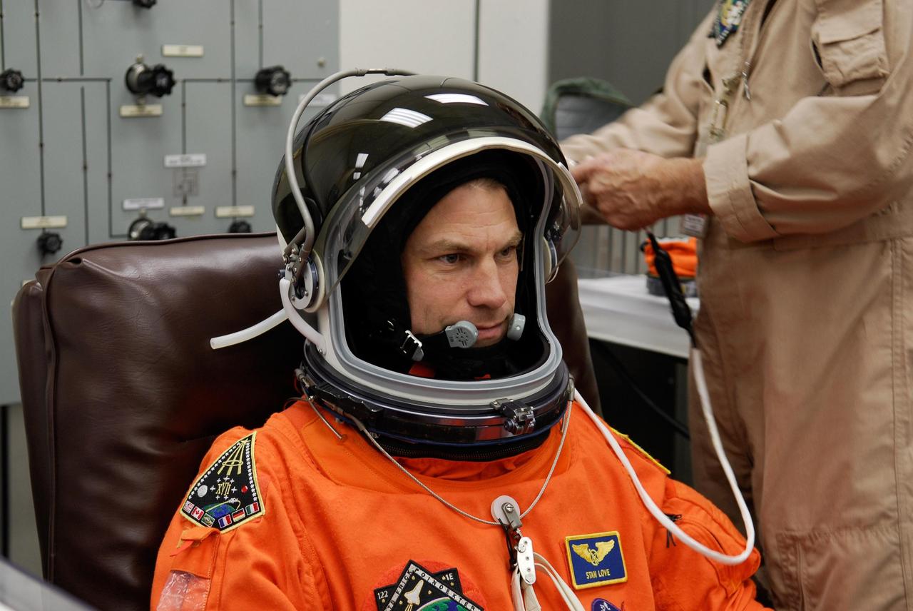 KENNEDY SPACE CENTER, FLA. -- A suit technician makes adjustments to space shuttle Atlantis STS-122 Mission Specialist Stanley Love's helmet, part of his launch and entry suit, in astronaut crew quarters. The STS-122 crew is preparing for a simulated launch countdown aboard Atlantis, part of terminal countdown demonstration test, or TCDT, activities at NASA's Kennedy Space Center. The TCDT is a dress rehearsal for launch and also provides astronauts and ground crews with equipment familiarization and emergency egress training. On mission STS-122, Atlantis will deliver the Columbus module to the International Space Station. The European Space Agency's largest single contribution to the station, Columbus is a multifunctional, pressurized laboratory that will be permanently attached to U.S. Node 2, called Harmony. The laboratory will expand the research facilities aboard the station, providing crew members and scientists from around the world the ability to conduct a variety of experiments in the physical, materials and life sciences. Launch is targeted for Dec. 6. Photo credit: NASA/Kim Shiflett