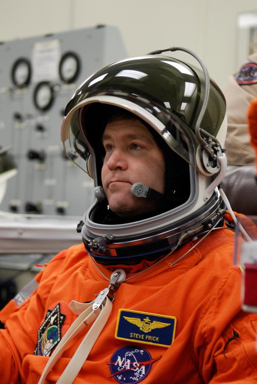 KENNEDY SPACE CENTER, FLA. -- Space shuttle Atlantis STS-122 Commander Steve Frick puts on his helmet, part of his launch and entry suit, in astronaut crew quarters. The STS-122 crew is preparing for a simulated launch countdown aboard Atlantis, part of terminal countdown demonstration test, or TCDT, activities at NASA's Kennedy Space Center. The TCDT is a dress rehearsal for launch and also provides astronauts and ground crews with equipment familiarization and emergency egress training. On mission STS-122, Atlantis will deliver the Columbus module to the International Space Station. The European Space Agency's largest single contribution to the station, Columbus is a multifunctional, pressurized laboratory that will be permanently attached to U.S. Node 2, called Harmony. The laboratory will expand the research facilities aboard the station, providing crew members and scientists from around the world the ability to conduct a variety of experiments in the physical, materials and life sciences. Launch is targeted for Dec. 6. Photo credit: NASA/Kim Shiflett