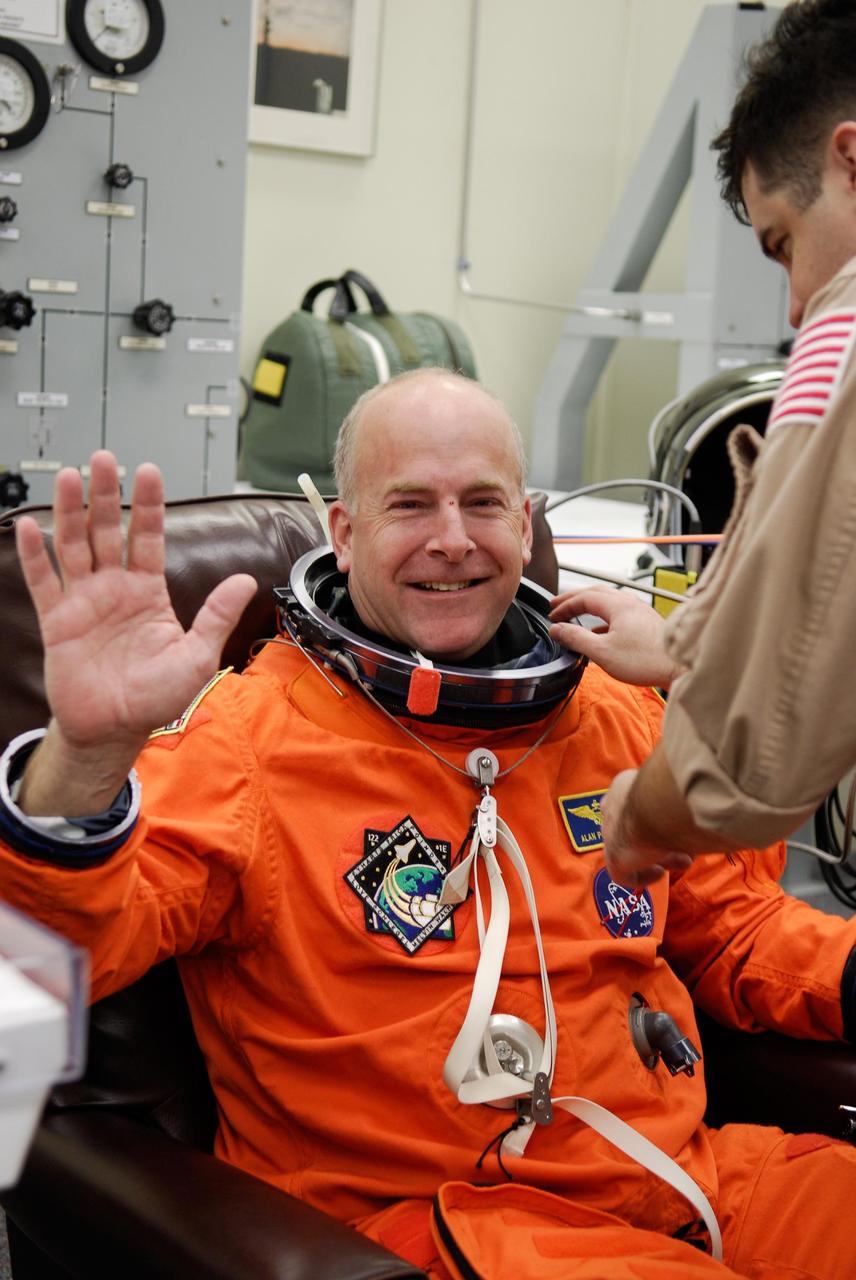 KENNEDY SPACE CENTER, FLA. -- A suit technician helps space shuttle Atlantis STS-122 Pilot Alan Poindexter put on his launch and entry suit, in astronaut crew quarters. The STS-122 crew is preparing for a simulated launch countdown aboard Atlantis, part of terminal countdown demonstration test, or TCDT, activities at NASA's Kennedy Space Center. The TCDT is a dress rehearsal for launch and also provides astronauts and ground crews with equipment familiarization and emergency egress training. On mission STS-122, Atlantis will deliver the Columbus module to the International Space Station. The European Space Agency's largest single contribution to the station, Columbus is a multifunctional, pressurized laboratory that will be permanently attached to U.S. Node 2, called Harmony. The laboratory will expand the research facilities aboard the station, providing crew members and scientists from around the world the ability to conduct a variety of experiments in the physical, materials and life sciences. Launch is targeted for Dec. 6. Photo credit: NASA/Kim Shiflett