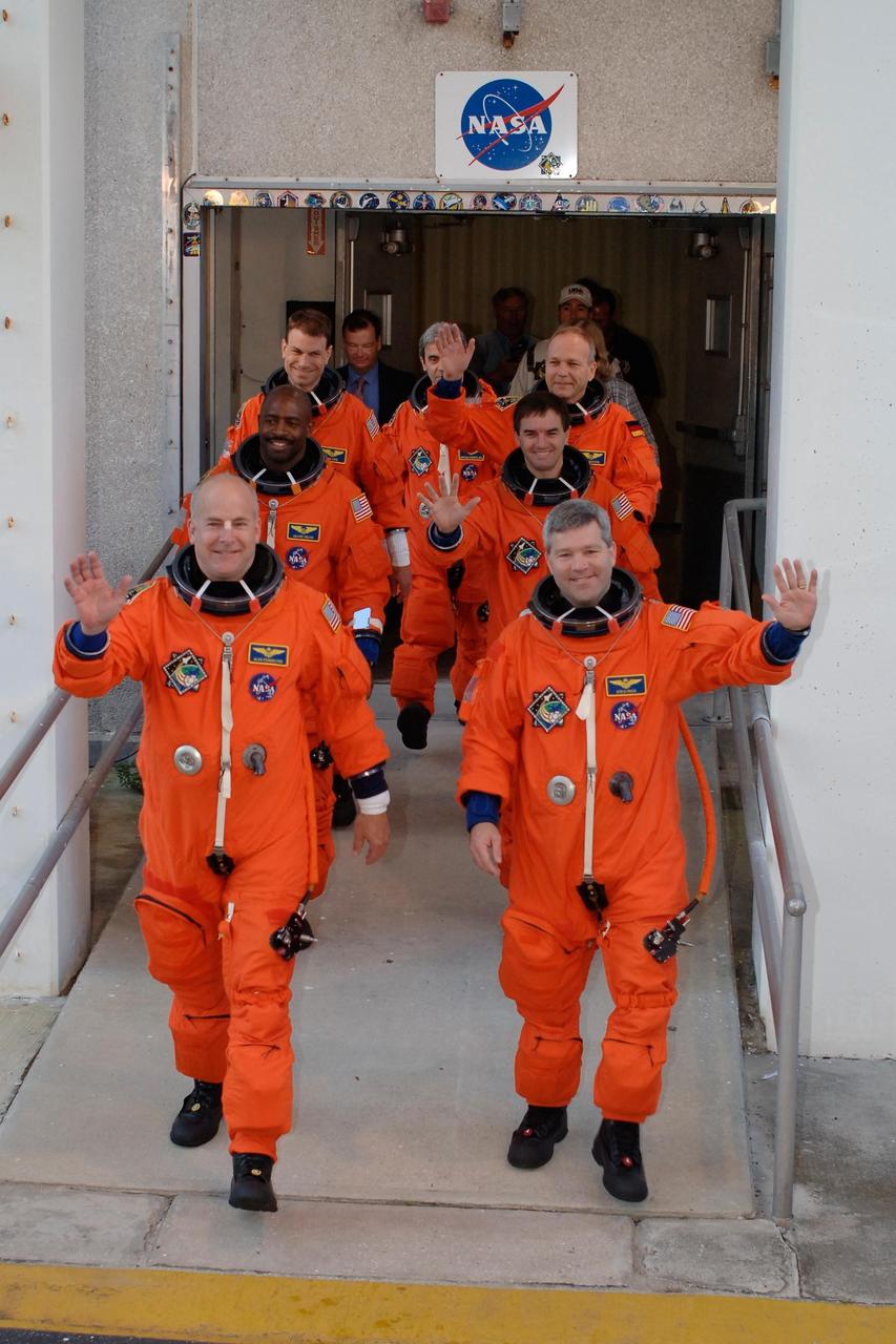 KENNEDY SPACE CENTER, FLA. -- Dressed in their launch and entry suits, the space shuttle Atlantis STS-122 crew greet the media and employees on hand to cheer them on as the leave the Operations and Checkout Building for Launch Pad 39A. Clockwise, from left front, are Pilot Alan Poindexter; Mission Specialists Leland Melvin, Stanley Love, Leopold Eyharts, Hans Schlegel, and Rex Walheim; and Commander Steve Frick. Eyharts and Schlegel are with the European Space Agency. Eyharts will remain on the International Space Station as a flight engineer for Expedition 16 following the STS-122 mission. The STS-122 crew is preparing for a simulated launch countdown aboard Atlantis, part of terminal countdown demonstration test, or TCDT, activities at NASA's Kennedy Space Center. The TCDT is a dress rehearsal for launch and also provides astronauts and ground crews with equipment familiarization and emergency egress training. On mission STS-122, Atlantis will deliver the Columbus module to the International Space Station. The European Space Agency's largest single contribution to the station, Columbus is a multifunctional, pressurized laboratory that will be permanently attached to U.S. Node 2, called Harmony. The laboratory will expand the research facilities aboard the station, providing crew members and scientists from around the world the ability to conduct a variety of experiments in the physical, materials and life sciences. Launch is targeted for Dec. 6. Photo credit: NASA/Kim Shiflett
