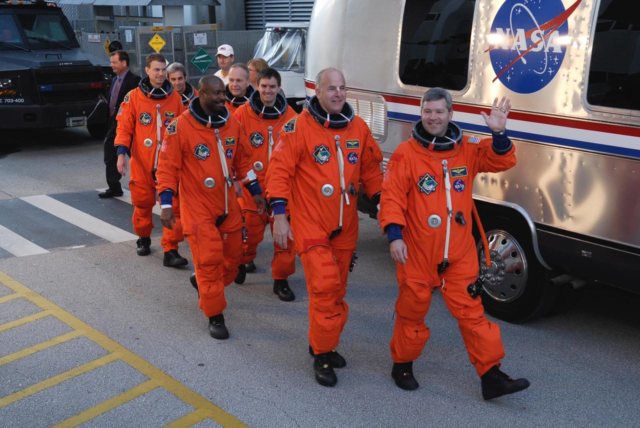 KENNEDY SPACE CENTER, FLA. -- Dressed in their launch and entry suits, the space shuttle Atlantis STS-122 crew leaves the Operations and Checkout Building for their trip to Launch Pad 39A aboard the astronaut van. From left are Mission Specialists Stanley Love, Leopold Eyharts, Leland Melvin, Hans Schlegel, and Rex Walheim; Pilot Alan Poindexter; and Commander Steve Frick. Eyharts and Schlegel are with the European Space Agency. Eyharts will remain on the International Space Station as a flight engineer for Expedition 16 following the STS-122 mission. The STS-122 crew is preparing for a simulated launch countdown aboard Atlantis, part of terminal countdown demonstration test, or TCDT, activities at NASA's Kennedy Space Center. The TCDT is a dress rehearsal for launch and also provides astronauts and ground crews with equipment familiarization and emergency egress training. On mission STS-122, Atlantis will deliver the Columbus module to the International Space Station. The European Space Agency's largest single contribution to the station, Columbus is a multifunctional, pressurized laboratory that will be permanently attached to U.S. Node 2, called Harmony. The laboratory will expand the research facilities aboard the station, providing crew members and scientists from around the world the ability to conduct a variety of experiments in the physical, materials and life sciences. Launch is targeted for Dec. 6. Photo credit: NASA/Kim Shiflett