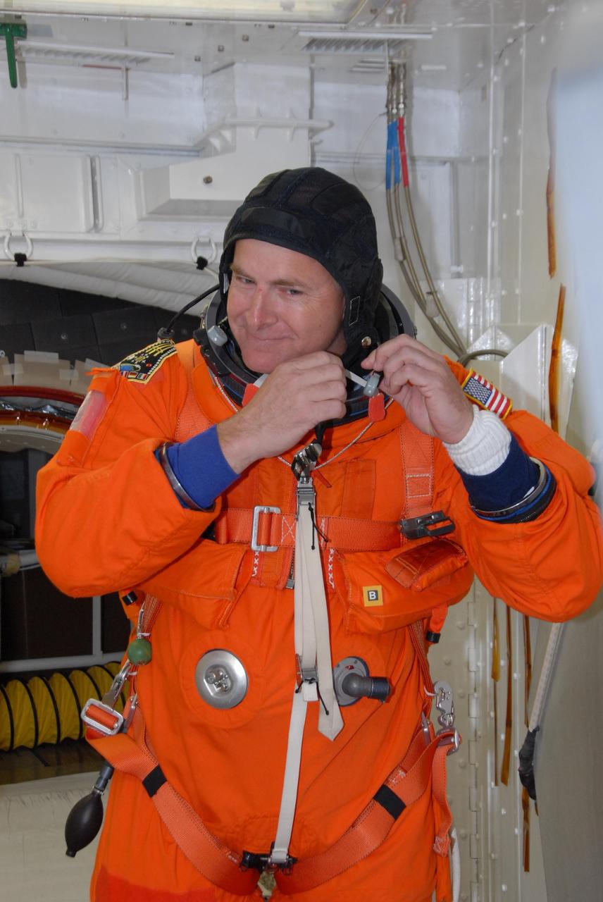 KENNEDY SPACE CENTER, FLA. --  In the White Room on Launch Pad 39A, space shuttle Atlantis STS-122 Pilot Alan Poindexter suits up for his entry into Atlantis' cockpit, through the hatch behind him.   The exercise is part of terminal countdown demonstration test, or TCDT, activities at NASA's Kennedy Space Center. The TCDT is a dress rehearsal for launch and also provides astronauts and ground crews with equipment familiarization and emergency egress training.  On mission STS-122, Atlantis will deliver the Columbus module to the International Space Station. The European Space Agency's largest single contribution to the station, Columbus is a multifunctional, pressurized laboratory that will be permanently attached to U.S. Node 2, called Harmony. The laboratory will expand the research facilities aboard the station, providing crew members and scientists from around the world the ability to conduct a variety of experiments in the physical, materials and life sciences. Atlantis' launch is targeted for Dec. 6.  Photo credit: NASA/George Shelton
