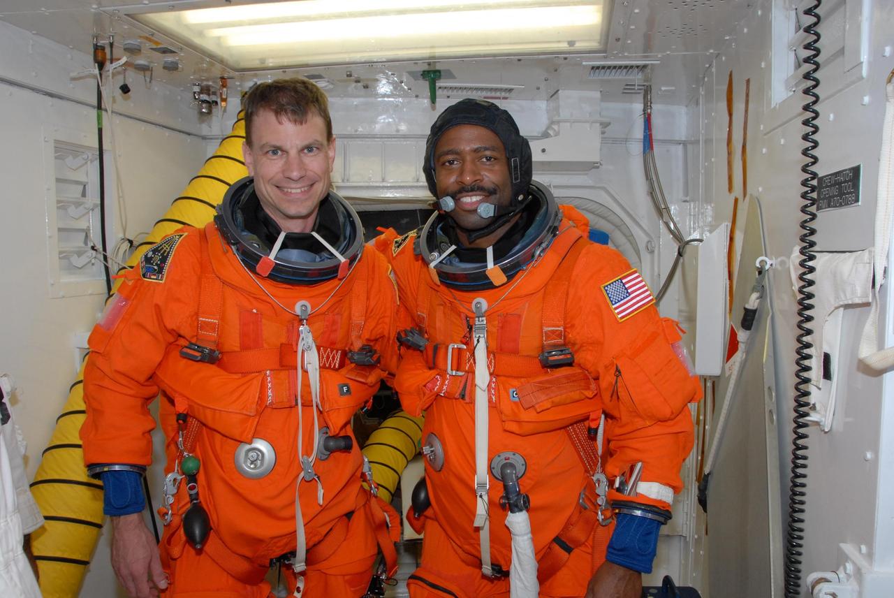 KENNEDY SPACE CENTER, FLA. --  In the White Room on Launch Pad 39A, space shuttle Atlantis STS-122 Mission Specialists Stanley Love and Leland Melvin take time out for a photo during their preparations for entry onto Atlantis' flight deck.    The exercise is part of terminal countdown demonstration test, or TCDT, activities at NASA's Kennedy Space Center. The TCDT is a dress rehearsal for launch and also provides astronauts and ground crews with equipment familiarization and emergency egress training.  On mission STS-122, Atlantis will deliver the Columbus module to the International Space Station. The European Space Agency's largest single contribution to the station, Columbus is a multifunctional, pressurized laboratory that will be permanently attached to U.S. Node 2, called Harmony. The laboratory will expand the research facilities aboard the station, providing crew members and scientists from around the world the ability to conduct a variety of experiments in the physical, materials and life sciences. Atlantis' launch is targeted for Dec. 6.  Photo credit: NASA/George Shelton