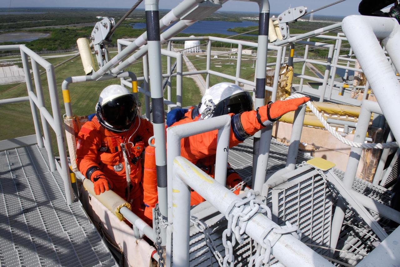 KENNEDY SPACE CENTER, FLA. --  Members of space shuttle Atlantis' STS-122 crew practice emergency exit procedures in a slidewire basket at Launch Pad 39A following a simulated launch countdown.   The exercise is part of terminal countdown demonstration test, or TCDT, activities at NASA's Kennedy Space Center. The TCDT is a dress rehearsal for launch and also provides astronauts and ground crews with equipment familiarization and emergency egress training.  On mission STS-122, Atlantis will deliver the Columbus module to the International Space Station. The European Space Agency's largest single contribution to the station, Columbus is a multifunctional, pressurized laboratory that will be permanently attached to U.S. Node 2, called Harmony. The laboratory will expand the research facilities aboard the station, providing crew members and scientists from around the world the ability to conduct a variety of experiments in the physical, materials and life sciences. Atlantis' launch is targeted for Dec. 6.  Photo credit: NASA/Kim Shiflett