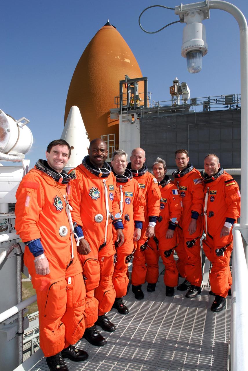 KENNEDY SPACE CENTER, FLA. --  Members of space shuttle Atlantis' STS-122 crew pose for a group portrait with the tip of Atlantis' external tank in the background following a simulated launch countdown at Launch Pad 39A.  From left are Mission Specialists Rex Walheim and Leland Melvin; Commander Steve Frick; Pilot Alan Poindexter; and Mission Specialists Leopold Eyharts, Stanley Love and Hans Schlegel.  Schlegel and Eyharts are with the European Space Agency.  Eyharts will remain on the International Space Station as a flight engineer for Expedition 16 following the STS-122 mission.   The exercise is part of terminal countdown demonstration test, or TCDT, activities at NASA's Kennedy Space Center. The TCDT is a dress rehearsal for launch and also provides astronauts and ground crews with equipment familiarization and emergency egress training.  On mission STS-122, Atlantis will deliver the Columbus module to the International Space Station. The European Space Agency's largest single contribution to the station, Columbus is a multifunctional, pressurized laboratory that will be permanently attached to U.S. Node 2, called Harmony. The laboratory will expand the research facilities aboard the station, providing crew members and scientists from around the world the ability to conduct a variety of experiments in the physical, materials and life sciences. Atlantis' launch is targeted for Dec. 6.  Photo credit: NASA/Kim Shiflett