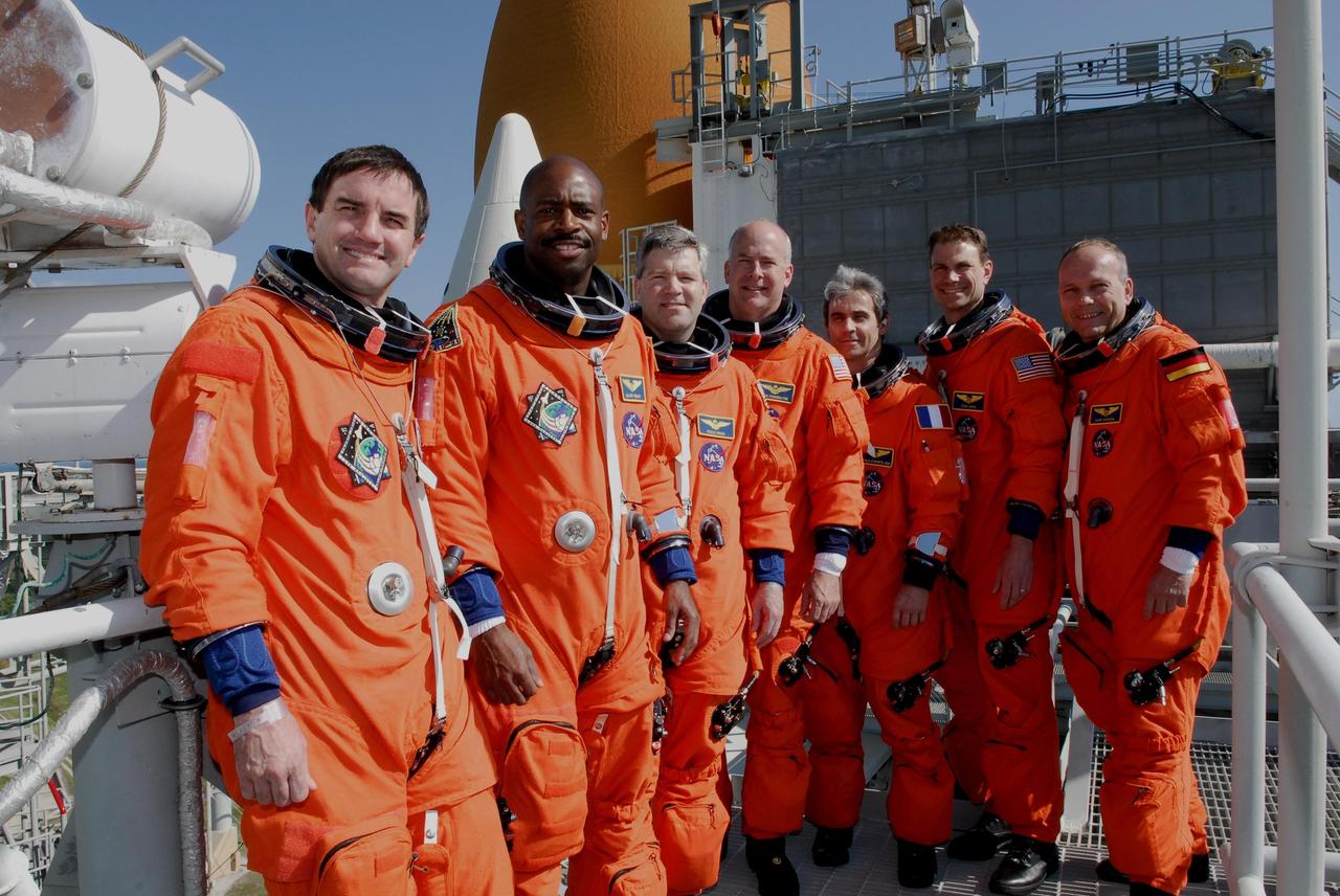 KENNEDY SPACE CENTER, FLA. --  Members of space shuttle Atlantis' STS-122 crew pose for a group portrait in front of Atlantis' external tank following a simulated launch countdown at Launch Pad 39A.  From left are Mission Specialists Rex Walheim and Leland Melvin; Commander Steve Frick; Pilot Alan Poindexter; and Mission Specialists Leopold Eyharts, Stanley Love and Hans Schlegel.  Schlegel and Eyharts are with the European Space Agency.  Eyharts will remain on the International Space Station as a flight engineer for Expedition 16 following the STS-122 mission.   The exercise is part of terminal countdown demonstration test, or TCDT, activities at NASA's Kennedy Space Center. The TCDT is a dress rehearsal for launch and also provides astronauts and ground crews with equipment familiarization and emergency egress training.  On mission STS-122, Atlantis will deliver the Columbus module to the International Space Station. The European Space Agency's largest single contribution to the station, Columbus is a multifunctional, pressurized laboratory that will be permanently attached to U.S. Node 2, called Harmony. The laboratory will expand the research facilities aboard the station, providing crew members and scientists from around the world the ability to conduct a variety of experiments in the physical, materials and life sciences. Atlantis' launch is targeted for Dec. 6.  Photo credit: NASA/Kim Shiflett