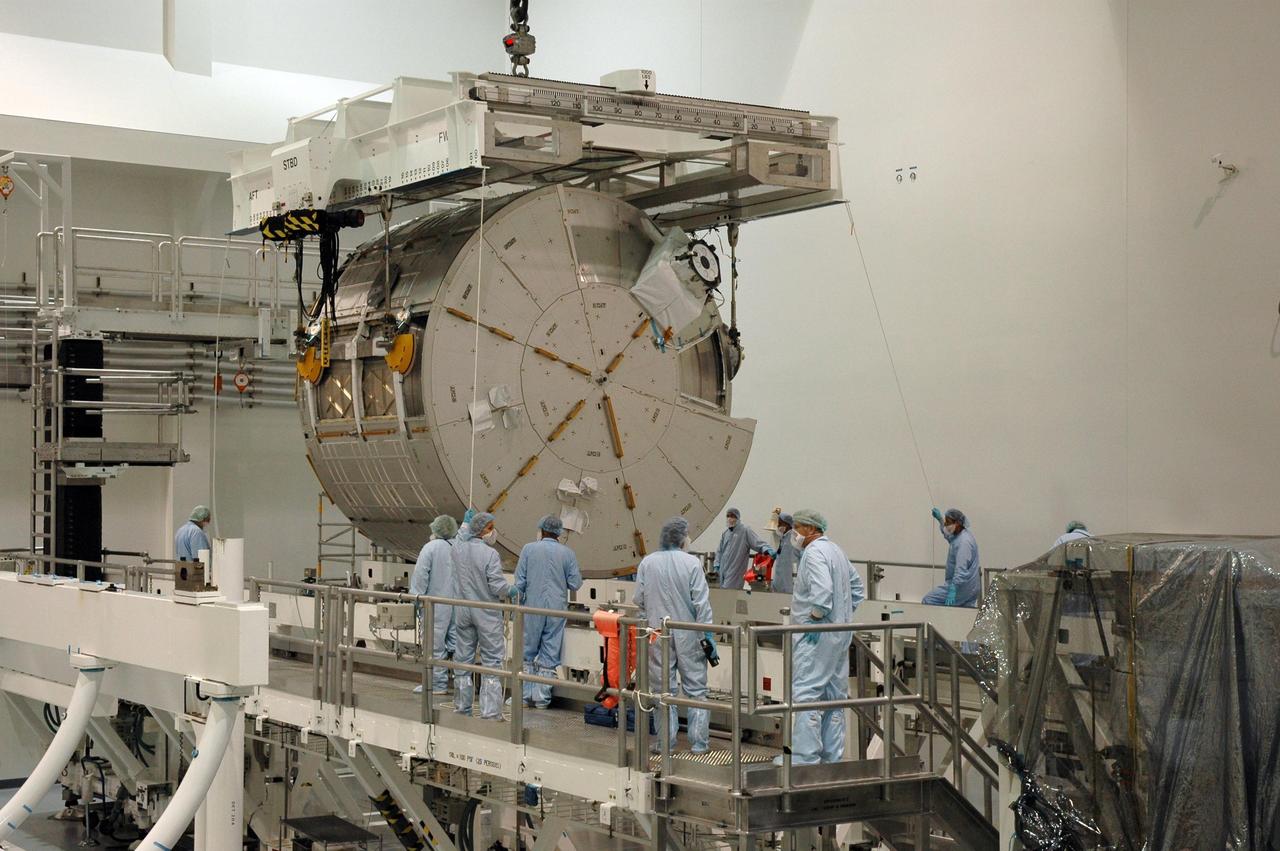 KENNEDY SPACE CENTER, FLA. -- In the Space Station Processing Facility at NASA's Kennedy Space Center, workers help guide the crane holding the Experiment Logistics Module Pressurized Section, or ELM-PS, which is being lowered toward a rotation stand. Part of the Japanese Experiment Module, called Kibo, the ELM-PS is the primary payload for space shuttle Endeavour's STS-123 mission, which is targeted for launch to the International Space Station on Feb. 14. Photo credit: NASA/Dimitri Gerondidakis
