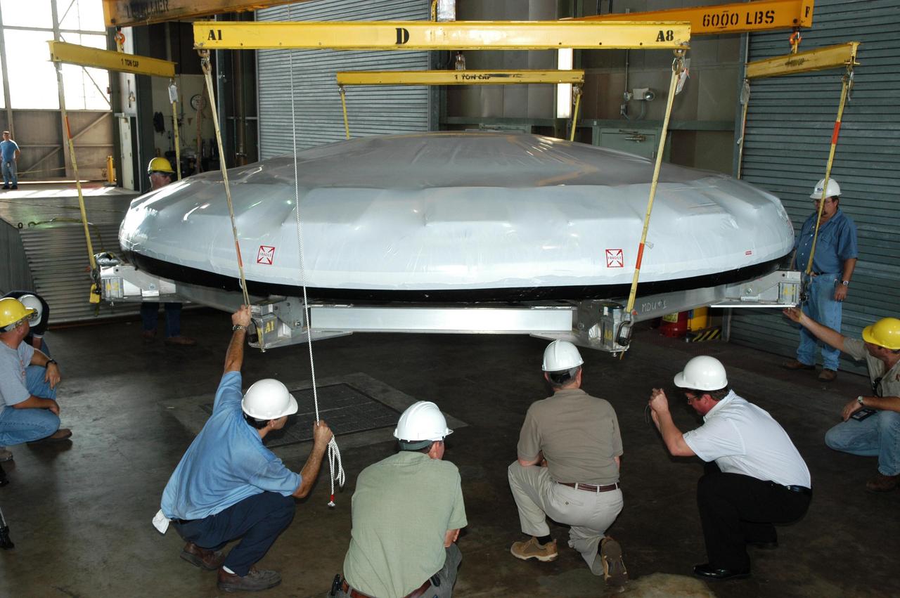 KENNEDY SPACE CENTER, FLA. --  In Hangar N at NASA's Kennedy Space Center, a heat shield for the Constellation crew exploration vehicle, or CEV, is being prepared for a demonstration.  A developmental heat shield for the Orion spacecraft is being tested and evaluated at Kennedy. The shield was designed and assembled by the Boeing Company in Huntington Beach, Calif., for NASA's Constellation Program. The thermal protection system manufacturing demonstration unit is designed to protect astronauts from extreme heat during re-entry to Earth's atmosphere from low Earth orbit and lunar missions. The CEV will be used to dock and gain access to the International Space Station, travel to the moon in the 2018 timeframe and play a crucial role in exploring Mars.  Photo credit: NASA/Kim Shiflett