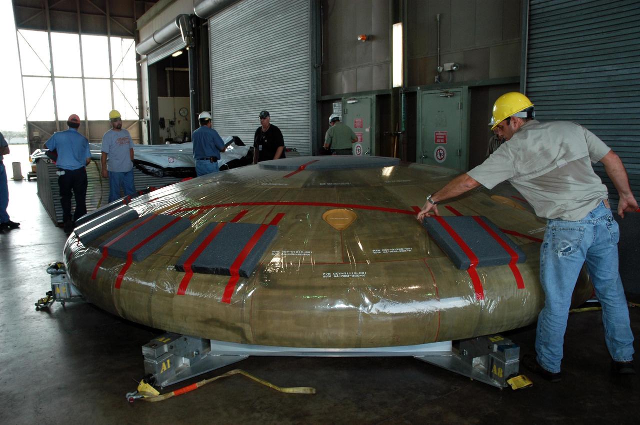 KENNEDY SPACE CENTER, FLA. --  In Hangar N at NASA's Kennedy Space Center, a heat shield for the Constellation crew exploration vehicle, or CEV, is being prepared for a demonstration.  A developmental heat shield for the Orion spacecraft is being tested and evaluated at Kennedy. The shield was designed and assembled by the Boeing Company in Huntington Beach, Calif., for NASA's Constellation Program. The thermal protection system manufacturing demonstration unit is designed to protect astronauts from extreme heat during re-entry to Earth's atmosphere from low Earth orbit and lunar missions. The CEV will be used to dock and gain access to the International Space Station, travel to the moon in the 2018 timeframe and play a crucial role in exploring Mars.  Photo credit: NASA/Kim Shiflett