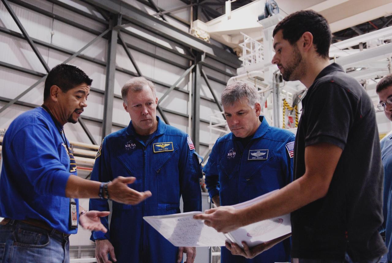 KENNEDY SPACE CENTER, FLA. --   In the Orbiter Processing Facility at NASA's Kennedy Space Center, STS-123 Commander Dominic Gorie (second from left) and Pilot Gregory Johnson (second from right) look over payload information.  On the mission, space shuttle Endeavour will carry the Special Purpose Dexterous Manipulator, known as Dextre, and the Japanese Experiment Module's Experiment Logistics Module Pressurized Section, or ELM-PS.  Dextre will work with the mobile base and Canadarm2 on the International Space Station to perform critical construction and maintenance tasks.  The crew is at Kennedy for crew equipment interface test, a process of familiarization with payloads, hardware and the space shuttle.  The STS-123 mission is targeted for launch on Feb. 14. It will be the 25th assembly flight of the station.  Photo credit: NASA/Kim Shiflett