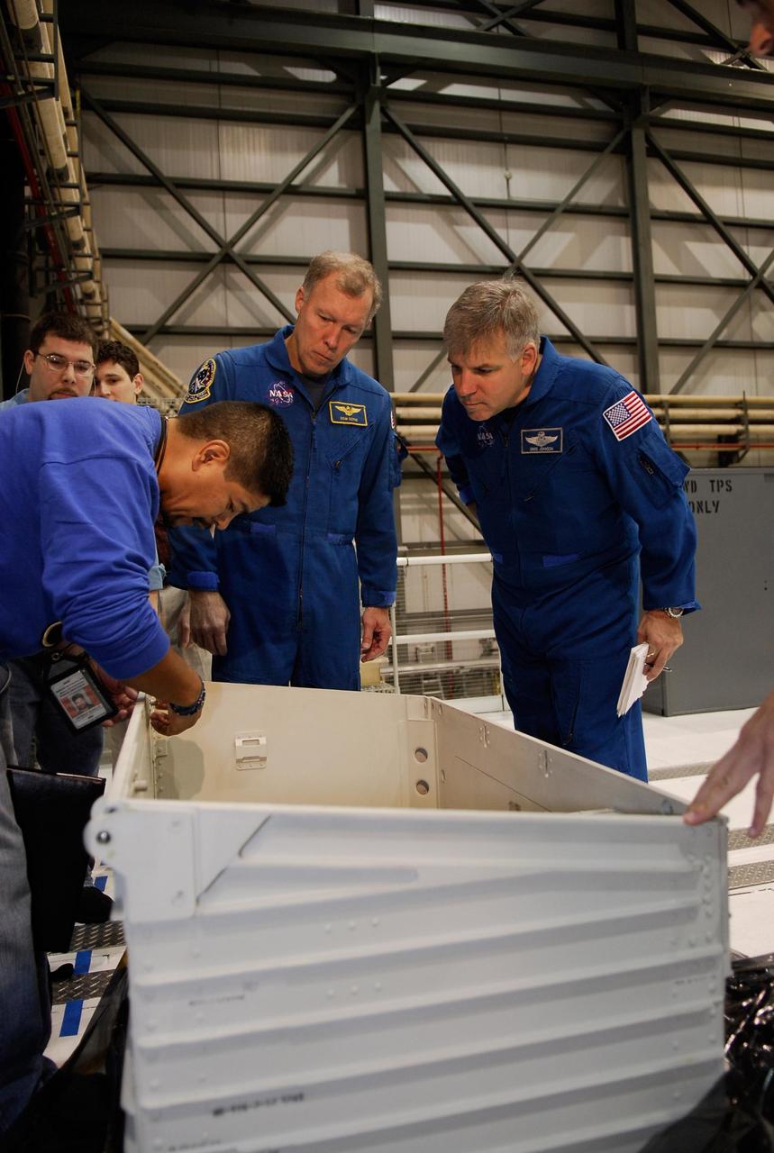 KENNEDY SPACE CENTER, FLA. --    In the Orbiter Processing Facility at NASA's Kennedy Space Center, space shuttle Endeavour's STS-123 Commander Dominic Gorie (center) and Pilot Gregory Johnson (right) look over equipment for the mission.   The crew is at Kennedy for crew equipment interface test, a process of familiarization with payloads, hardware and the space shuttle.  The STS-123 mission is targeted for launch on Feb. 14. It will be the 25th assembly flight of the station.  Photo credit: NASA/Kim Shiflett