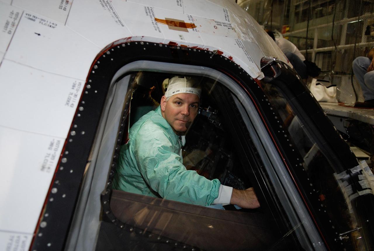 KENNEDY SPACE CENTER, FLA. --   In the Orbiter Processing Facility at NASA's Kennedy Space Center, space shuttle Endeavour's STS-123 Pilot Gregory Johnson inspects the window in space shuttle Endeavour. The crew is at Kennedy for crew equipment interface test, a process of familiarization with payloads, hardware and the space shuttle.  The STS-123 mission is targeted for launch on Feb. 14. It will be the 25th assembly flight of the station.  Photo credit: NASA/Kim Shiflett