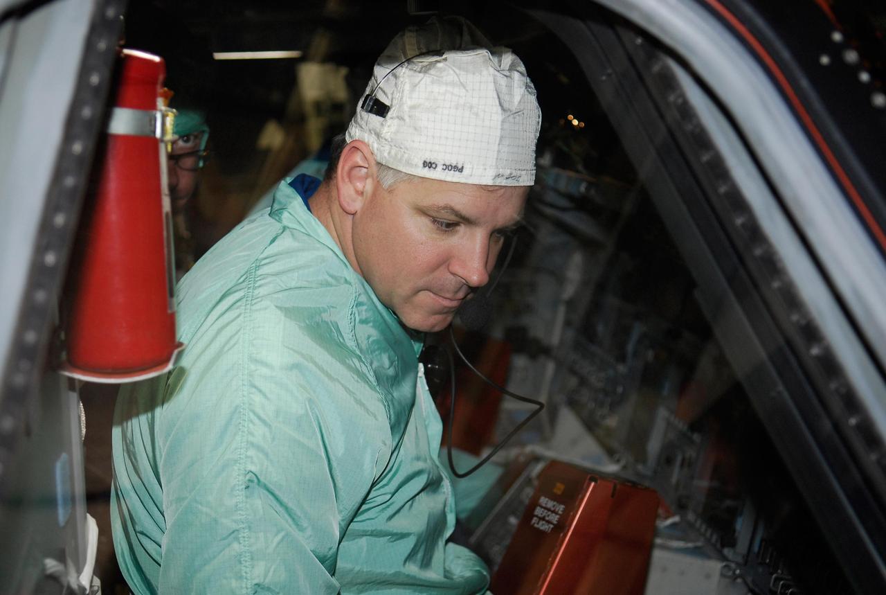KENNEDY SPACE CENTER, FLA. --   In the Orbiter Processing Facility at NASA's Kennedy Space Center, space shuttle Endeavour's STS-123 Pilot Gregory Johnson inspects the window in space shuttle Endeavour. The crew is at Kennedy for crew equipment interface test, a process of familiarization with payloads, hardware and the space shuttle.  The STS-123 mission is targeted for launch on Feb. 14. It will be the 25th assembly flight of the station.  Photo credit: NASA/Kim Shiflett