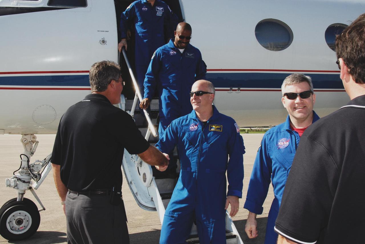 KENNEDY SPACE CENTER, FLA. -- Center Director Bill Parsons welcomes STS-122 Pilot Alan Poindexter after the mission crew's arrival at NASA's Kennedy Space Center. At right is Commander Steve Frick. Seen behind Poindexter is Mission Specialist Leland Melvin. The crew's arrival signals the imminent launch of space shuttle Atlantis on mission STS-122. The launch countdown begins at 7 p.m. Dec. 3. Launch is scheduled for 4:31 p.m. EST on Dec. 6. Atlantis will carry the Columbus Lab, Europe's largest contribution to the construction of the International Space Station. It will support scientific and technological research in a microgravity environment. Columbus, a program of ESA, is a multifunctional, pressurized laboratory that will be permanently attached to Node 2 of the space station to carry out experiments in materials science, fluid physics and biosciences, as well as to perform a number of technological applications. Photo credit: NASA/Kim Shiflett