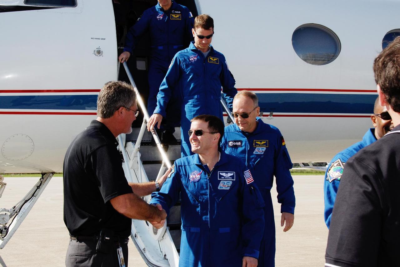 KENNEDY SPACE CENTER, FLA. -- Center Director Bill Parsons welcomes STS-122 Mission Specialist Rex Walheim after the mission crew's arrival at NASA's Kennedy Space Center. Behind Walheim are Mission Specialists Hans Schlegel and Stanley Love. Schlegel represents the European Space Agency. The crew's arrival signals the imminent launch of space shuttle Atlantis on mission STS-122. The launch countdown begins at 7 p.m. Dec. 3. Launch is scheduled for 4:31 p.m. EST on Dec. 6. Atlantis will carry the Columbus Lab, Europe's largest contribution to the construction of the International Space Station. It will support scientific and technological research in a microgravity environment. Columbus, a program of ESA, is a multifunctional, pressurized laboratory that will be permanently attached to Node 2 of the space station to carry out experiments in materials science, fluid physics and biosciences, as well as to perform a number of technological applications. Photo credit: NASA/Kim Shiflett
