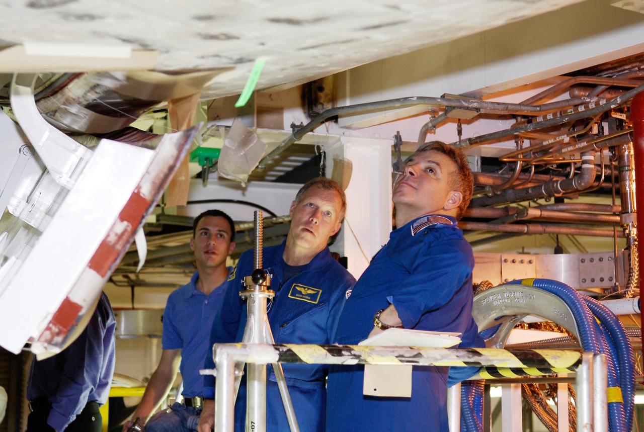 KENNEDY SPACE CENTER, FLA. --  In the Orbiter Processing Facility, STS-123 crew members inspect the thermal protection system tiles on the underside of space shuttle Endeavour.  At center is Commander Dominic Gorie; at right is Pilot Gregory Johnson.  They and other crew members are at NASA's Kennedy Space Center for a crew equipment interface test, a process of familiarization with payloads, hardware and the space shuttle. The STS-123 mission is targeted for launch on space shuttle Endeavour on Feb. 14.  It will be the 25th assembly flight of the station.   Photo credit: NASA/Kim Shiflett
