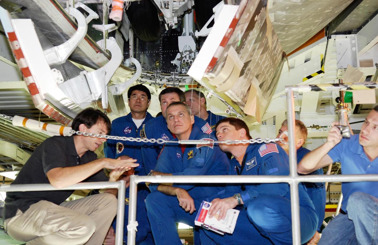 KENNEDY SPACE CENTER, FLA. -- In the Orbiter Processing Facility, STS-123 crew members inspect the wheel well on the underside of space shuttle Endeavour. Seen kneeling in front are Mission Specialists Richard Linnehan, Robert Behnken and Pilot Gregory Johnson. Behind them are Mission Specialists Takao Doi and Michael Foreman and Commander Dominic Gorie. They are at NASA's Kennedy Space Center for a crew equipment interface test, a process of familiarization with payloads, hardware and the space shuttle. The STS-123 mission is targeted for launch on space shuttle Endeavour on Feb. 14. It will be the 25th assembly flight of the station. Photo credit: NASA/Kim Shiflett