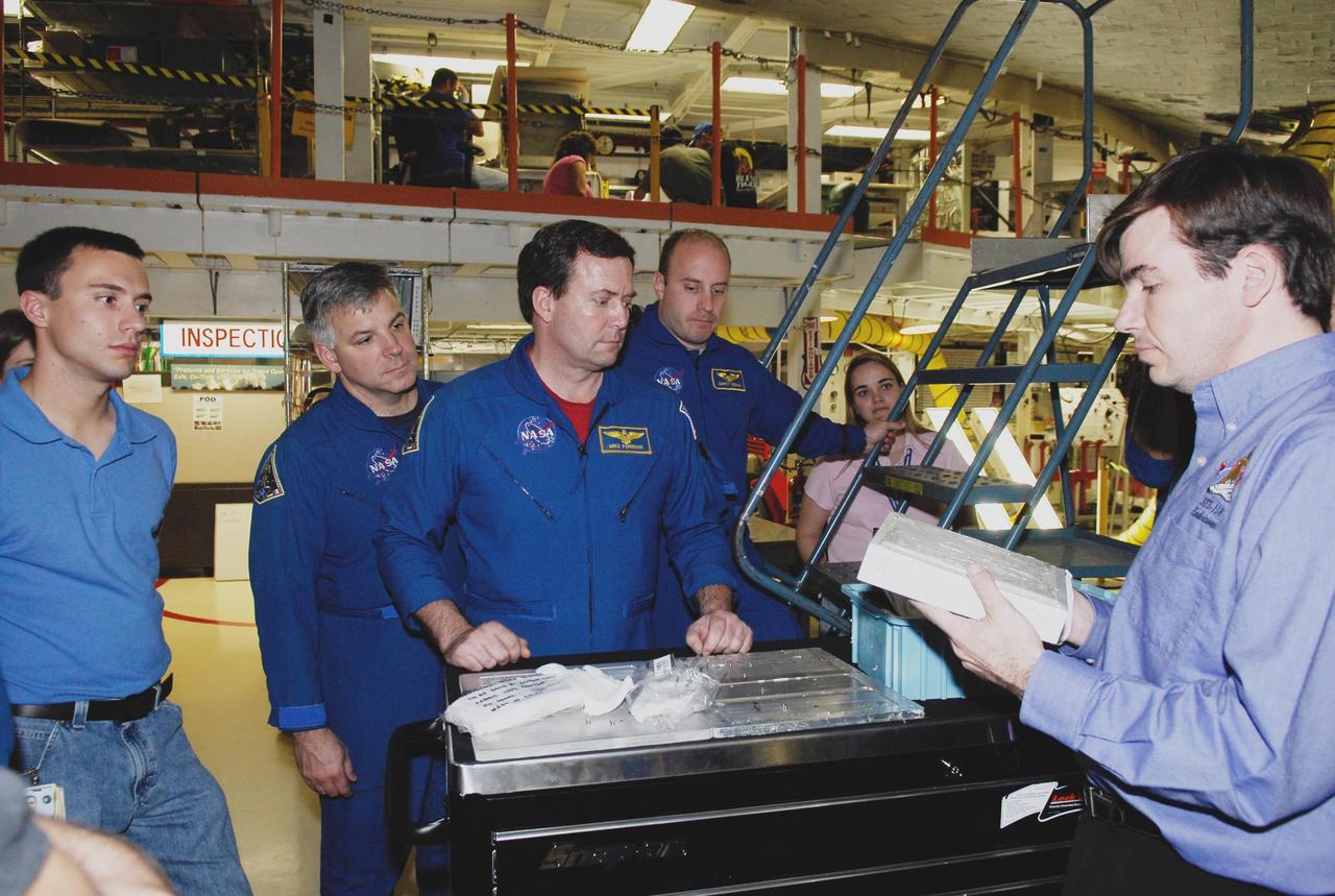 KENNEDY SPACE CENTER, FLA. --  In the Orbiter Processing Facility, STS-123 crew members look over some of the equipment for the mission.  From left are Pilot Gregory Johnson and Mission Specialists Michael Foreman and Garrett Reisman.  They and other crew members are at NASA's Kennedy Space Center for a crew equipment interface test, a process of familiarization with payloads, hardware and the space shuttle. The STS-123 mission is targeted for launch on space shuttle Endeavour on Feb. 14.  It will be the 25th assembly flight of the station.   Photo credit: NASA/Kim Shiflett