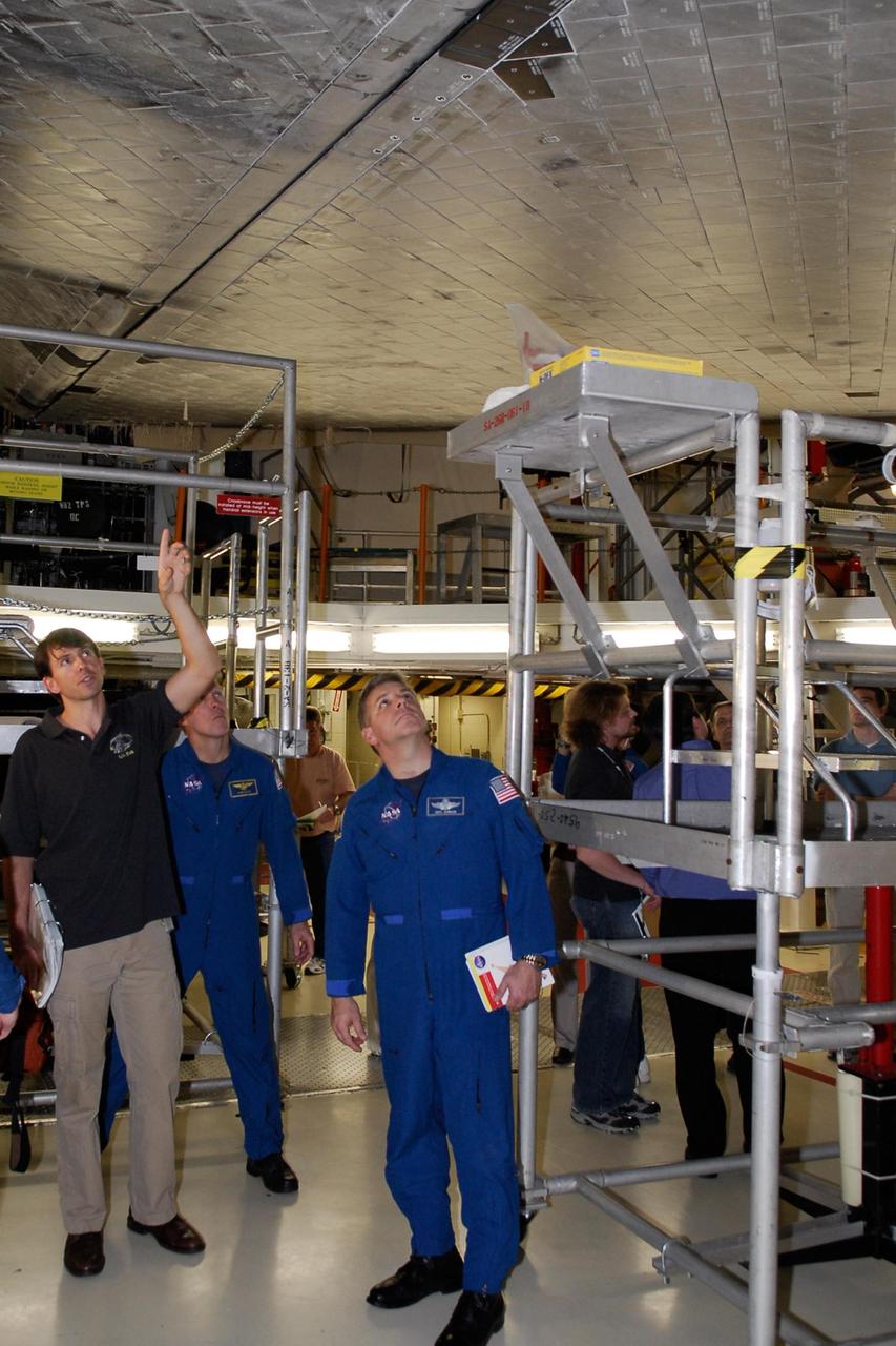 KENNEDY SPACE CENTER, FLA. --  In the Orbiter Processing Facility, STS-123 Commander Dominic Gorie (center) and Pilot Gregory Johnson (right) inspect the thermal protection system tiles on the underside of space shuttle Endeavour. They and other crew members are at NASA's Kennedy Space Center for a crew equipment interface test, a process of familiarization with payloads, hardware and the space shuttle.  The STS-123 mission is targeted for launch on space shuttle Endeavour on Feb. 14.  It will be the 25th assembly flight of the station.   Photo credit: NASA/Kim Shiflett