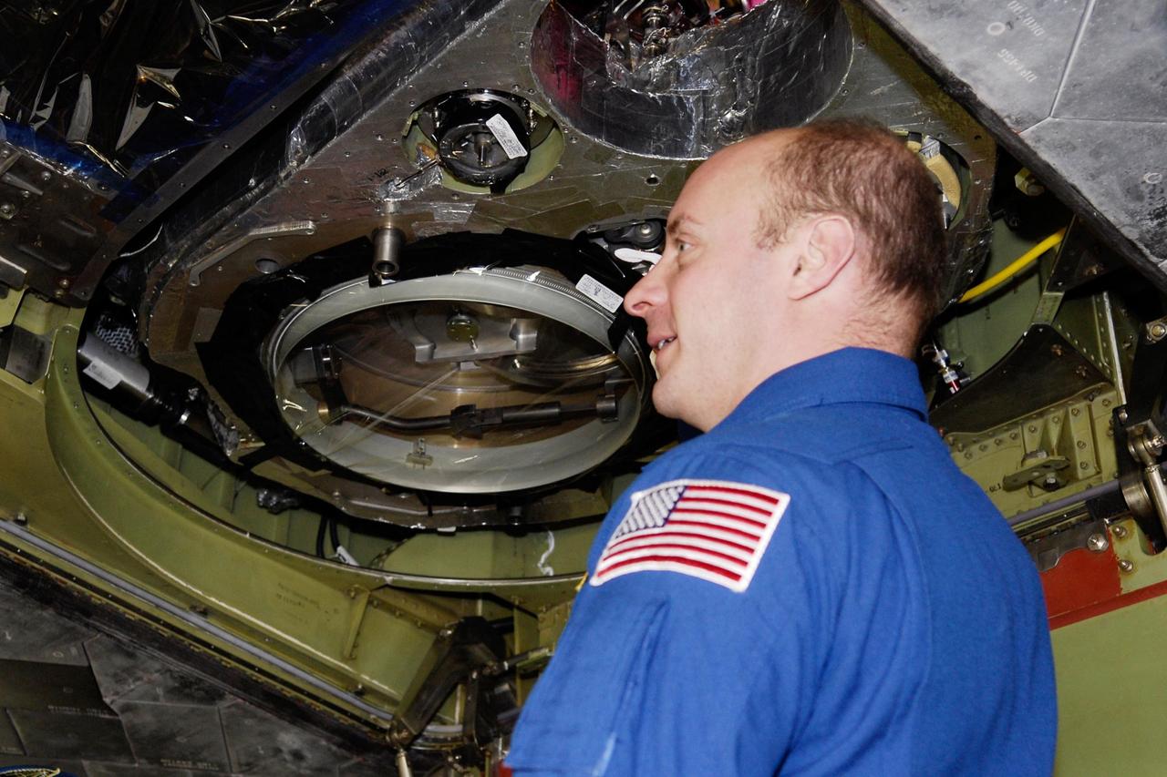 KENNEDY SPACE CENTER, FLA. -- In the Orbiter Processing Facility, STS-123 Mission Specialist Garrett Reisman inspects the underside of space shuttle Endeavour. He and other crew members are at NASA's Kennedy Space Center for a crew equipment interface test, a process of familiarization with payloads, hardware and the space shuttle. Reisman will join the Expedition 16 crew on the International Space Station, replacing flight engineer Leopold Eyharts. The STS-123 mission is targeted for launch on space shuttle Endeavour on Feb. 14. It will be the 25th assembly flight of the station. Photo credit: NASA/Kim Shiflett
