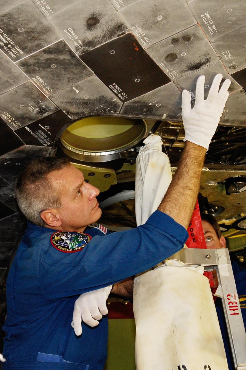 KENNEDY SPACE CENTER, FLA. -- In the Orbiter Processing Facility, STS-123 Mission Specialist Richard Linnehan makes a hands-on inspection of the thermal protection system tiles on the underside of space shuttle Endeavour. He and other crew members are at NASA's Kennedy Space Center for a crew equipment interface test, a process of familiarization with payloads, hardware and the space shuttle. The STS-123 mission is targeted for launch on space shuttle Endeavour on Feb. 14. It will be the 25th assembly flight of the station. Photo credit: NASA/Kim Shiflett