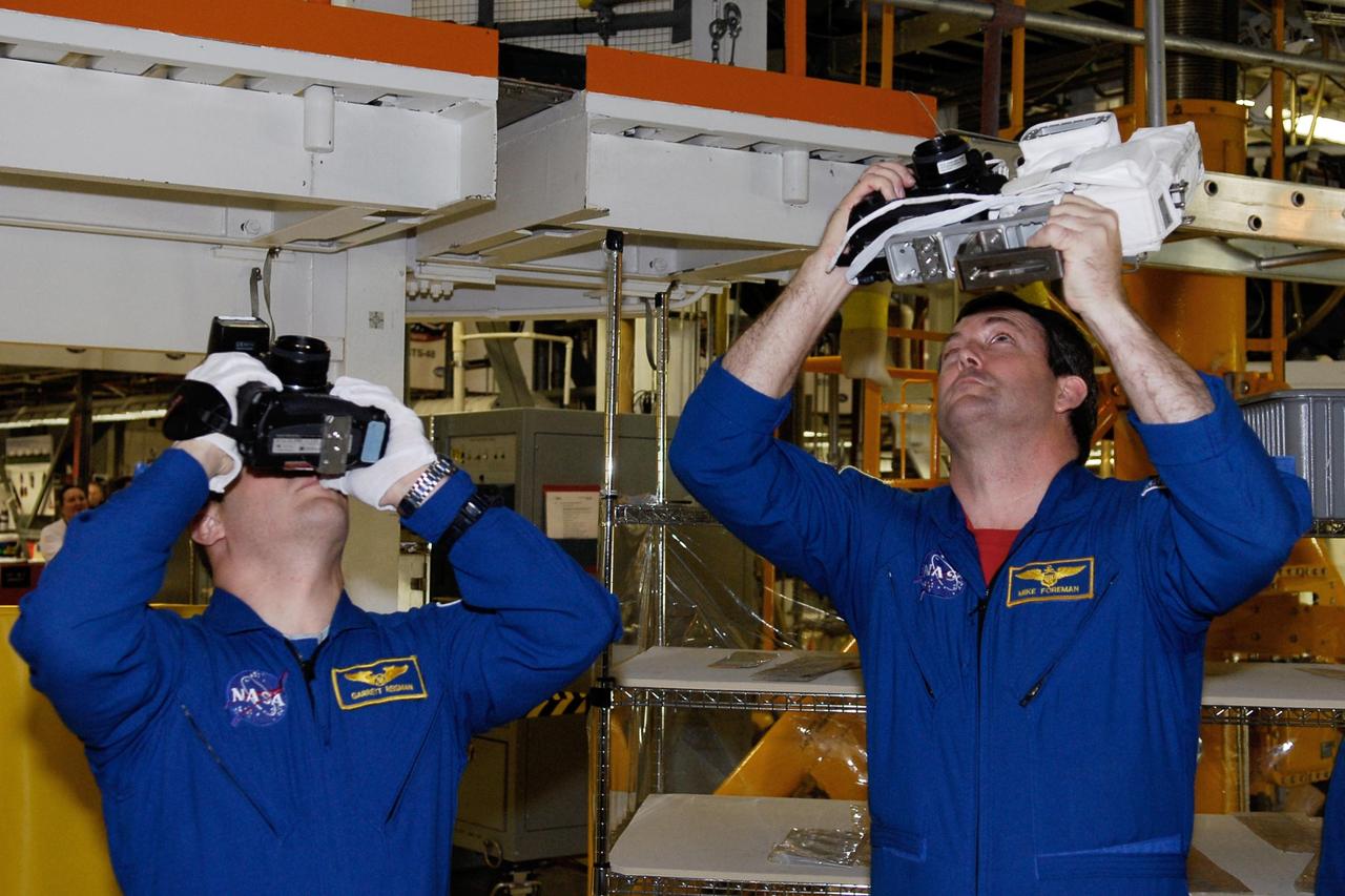KENNEDY SPACE CENTER, FLA. -- In the Orbiter Processing Facility, STS-123 Mission Specialists Garrett Reisman and Michael Foreman practice using the cameras that will be on the mission. They and other crew members are at NASA's Kennedy Space Center for a crew equipment interface test, a process of familiarization with payloads, hardware and the space shuttle. Reisman will join the Expedition 16 crew on the International Space Station, replacing flight engineer Leopold Eyharts. The STS-123 mission is targeted for launch on space shuttle Endeavour on Feb. 14. It will be the 25th assembly flight of the station. Photo credit: NASA/Kim Shiflett