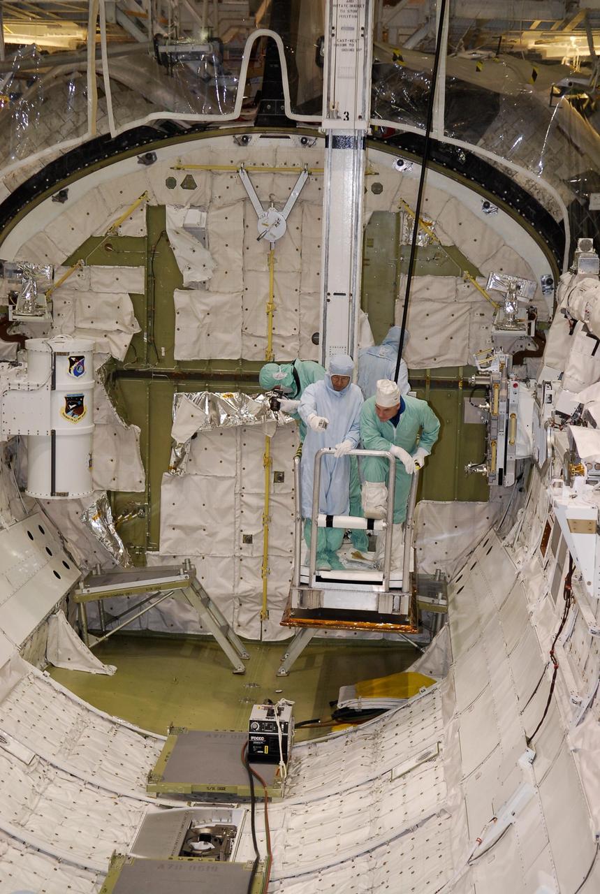 KENNEDY SPACE CENTER, FLA. -- In the Orbiter Processing Facility, STS-123 crew members are lowered into space shuttle Endeavour's payload bay to check out the equipment. At right is Mission Specialist Garrett Reisman; at left is Mission Specialist Takao Doi. The crew is at NASA's Kennedy Space Center for a crew equipment interface test, a process of familiarization with payloads, hardware and the space shuttle. Doi represents the Japanese Aerospace and Exploration Agency. Reisman will join the Expedition 16 crew on the International Space Station, replacing flight engineer Leopold Eyharts. The STS-123 mission is targeted for launch on space shuttle Endeavour on Feb. 14. It will be the 25th assembly flight of the station. Photo credit: NASA/Kim Shiflett