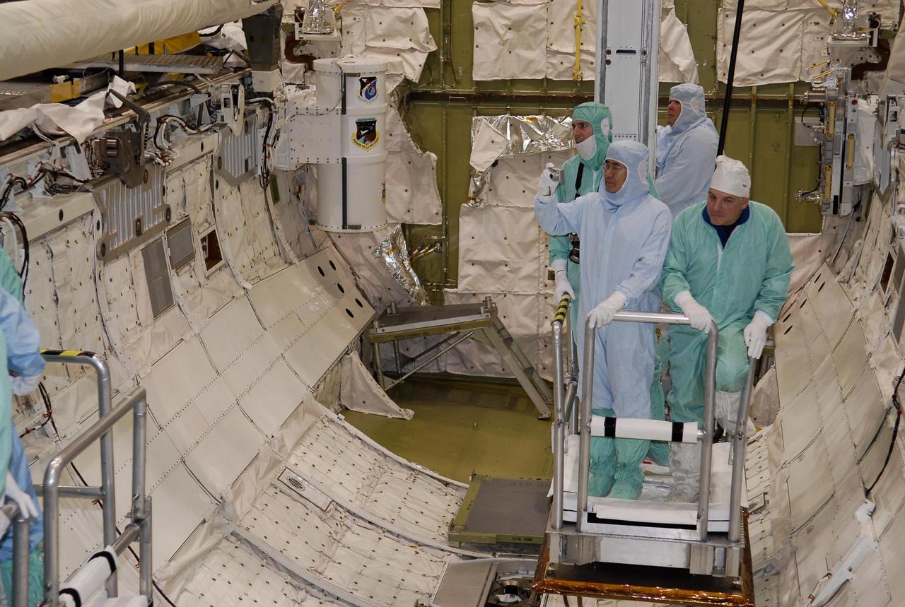 KENNEDY SPACE CENTER, FLA. -- In the Orbiter Processing Facility, STS-123 crew members are lowered into space shuttle Endeavour's payload bay to check out the equipment. At right is Mission Specialist Garrett Reisman; at left is Mission Specialist Takao Doi. The crew is at NASA's Kennedy Space Center for a crew equipment interface test, a process of familiarization with payloads, hardware and the space shuttle. Doi represents the Japanese Aerospace and Exploration Agency. Reisman will join the Expedition 16 crew on the International Space Station, replacing flight engineer Leopold Eyharts. The STS-123 mission is targeted for launch on space shuttle Endeavour on Feb. 14. It will be the 25th assembly flight of the station. Photo credit: NASA/Kim Shiflett