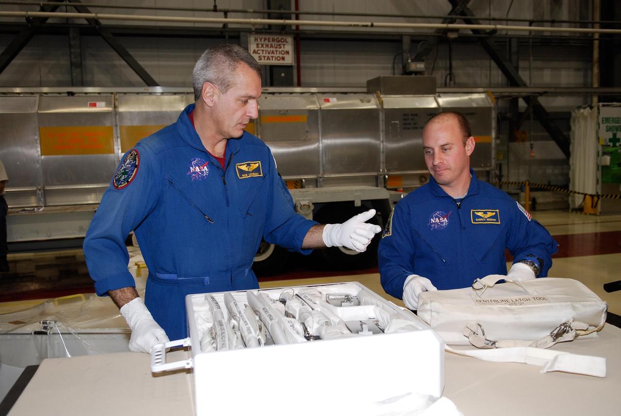KENNEDY SPACE CENTER, FLA. -- In the Orbiter Processing Facility, STS-123 crew members get a close look at equipment for the mission. Seen are Mission Specialists Richard Linnehan (left) and Garrett Reisman, who will join the Expedition 16 crew on the International Space Station, replacing flight engineer Leopold Eyharts. They and other crew members are at NASA's Kennedy Space Center for a crew equipment interface test, a process of familiarization with payloads, hardware and the space shuttle. The STS-123 mission is targeted for launch on space shuttle Endeavour on Feb. 14. It will be the 25th assembly flight of the station. Photo credit: NASA/Kim Shiflett