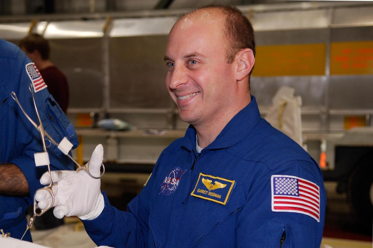 KENNEDY SPACE CENTER, FLA. -- In the Orbiter Processing Facility, STS-123 Mission Specialist Garrett Reisman practices with tools that will be used on the mission. He and other crew members are at NASA's Kennedy Space Center for a crew equipment interface test, a process of familiarization with payloads, hardware and the space shuttle. Reisman will join the Expedition 16 crew on the International Space Station, replacing flight engineer Leopold Eyharts. The STS-123 mission is targeted for launch on space shuttle Endeavour on Feb. 14. It will be the 25th assembly flight of the station. Photo credit: NASA/Kim Shiflett