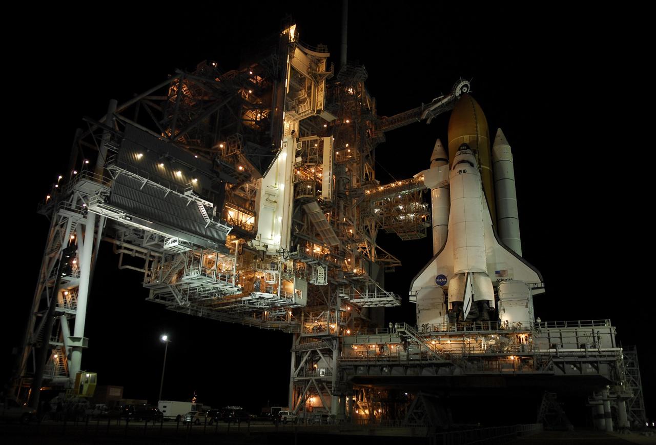 KENNEDY SPACE CENTER, FLA. -- Space shuttle Atlantis is revealed on Launch Pad 39A at NASA's Kennedy Space Center after the rotating service structure, or RSS, at left of the pad is rolled back. Rollback was complete at 8:44 p.m. EST. The RSS provides protected access to the orbiter for crew entry and servicing of payloads at the pad. Rollback of the pad's RSS is one of the milestones in preparation for the launch of mission STS-122, scheduled for 4:31 p.m. EST on Dec. 6.  Beneath the shuttle is the mobile launcher platform which supports the shuttle until liftoff.   Atlantis will carry the Columbus Laboratory, the European Space Agency's largest contribution to the construction of the International Space Station. It will support scientific and technological research in a microgravity environment.  Permanently attached to Node 2 of the space station, the laboratory will carry out experiments in materials science, fluid physics and biosciences, as well as perform a number of technological applications.  Photo credit: NASA/Kim Shiflett